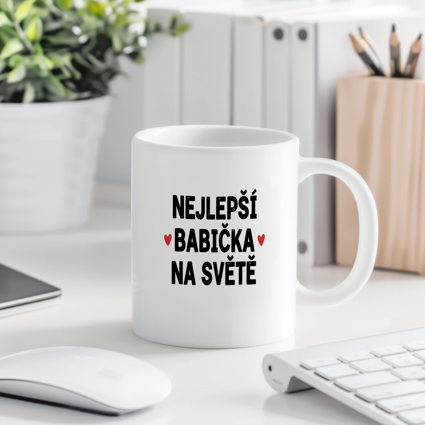 Bílý hrnek s nápisem NEJLEPŠÍ BABIČKA NA SVĚTĚ a červenými srdíčky.