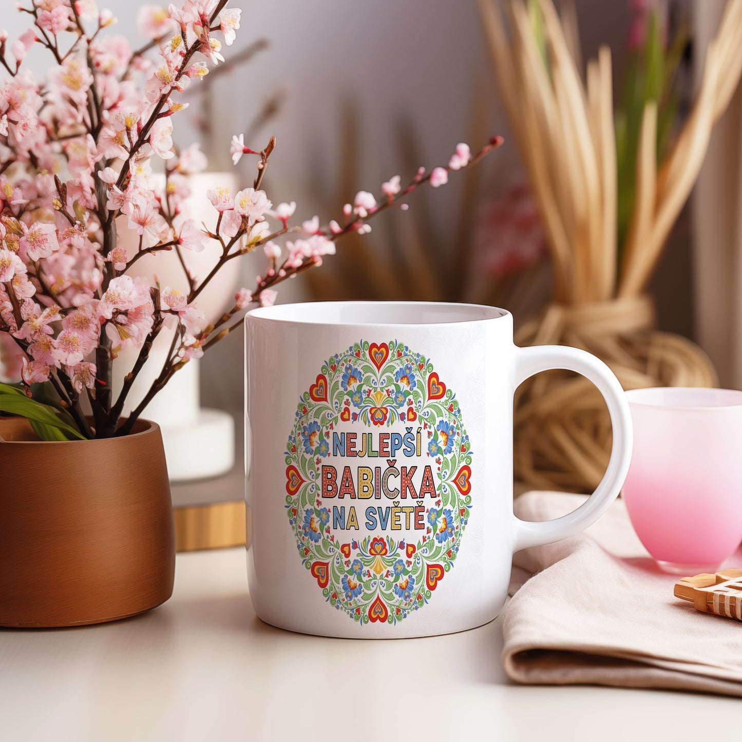 Hrnek s nápisem NEJLEPŠÍ BABIČKA NA SVĚTĚ a květinovými motivy.