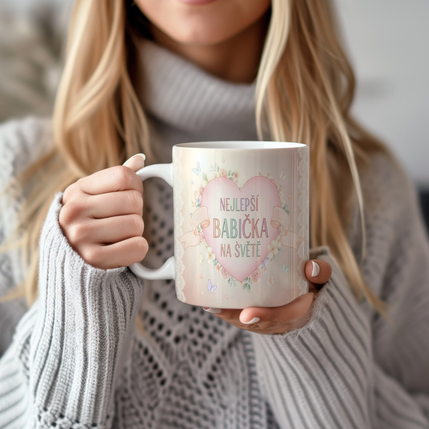 Hrnek s nápisem NEJLEPŠÍ BABIČKA NA SVĚTĚ, ozdobený květinami a motýly.