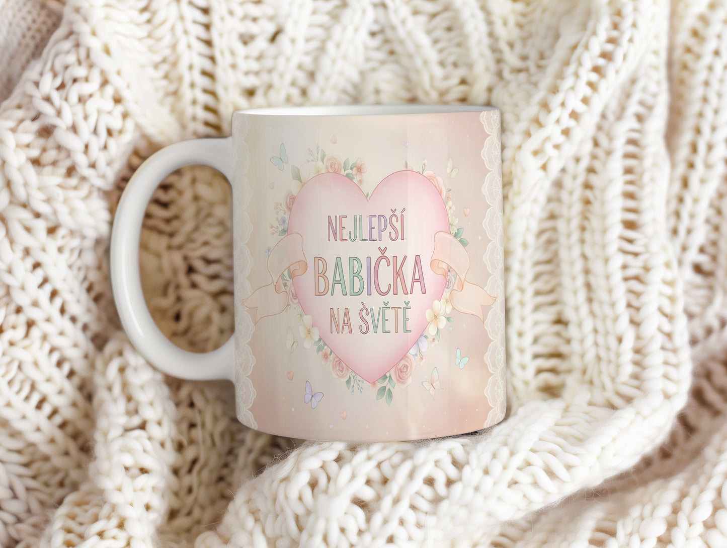Hrnek s nápisem NEJLEPŠÍ BABIČKA NA SVĚTĚ, ozdobený květinami a motýly.