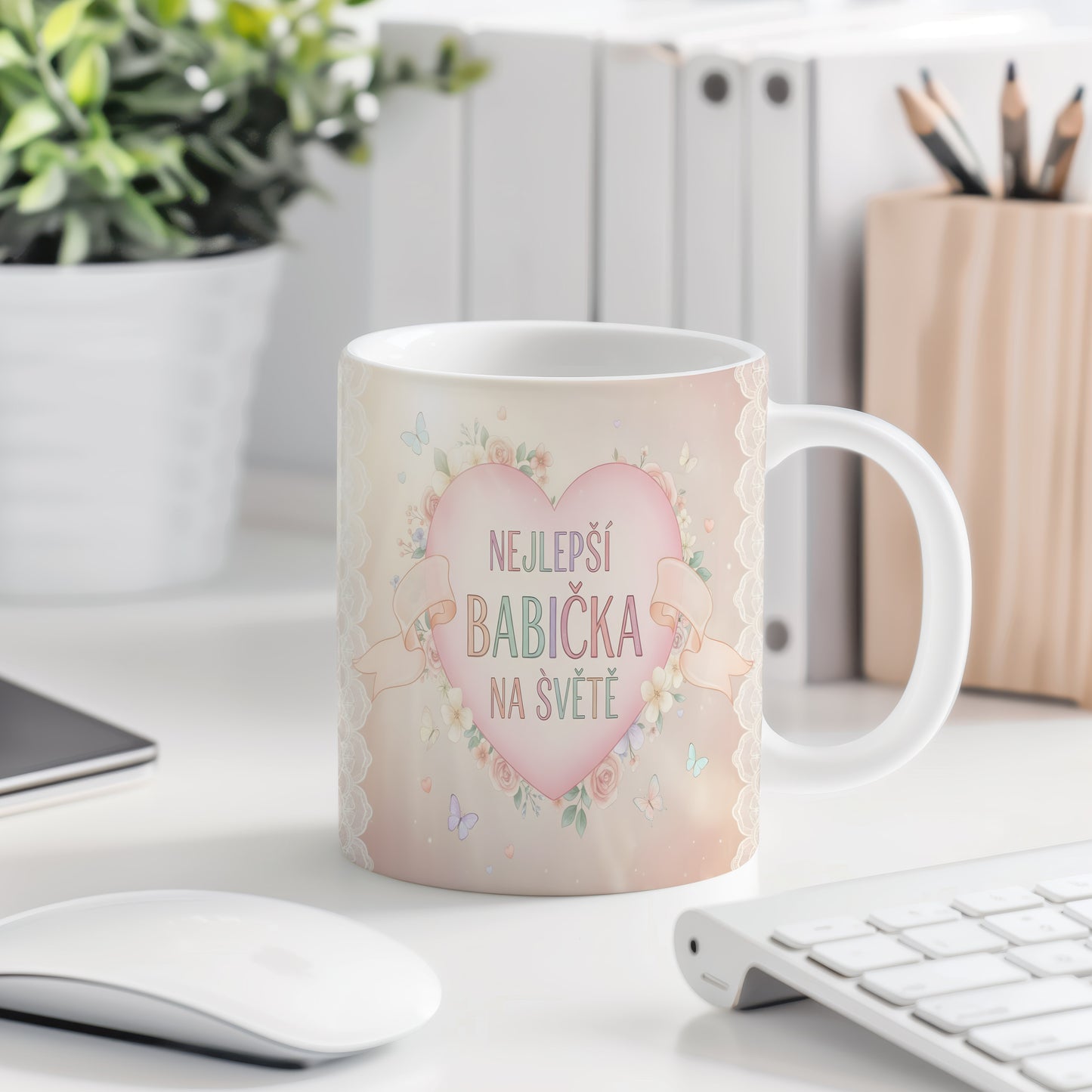Hrnek s nápisem NEJLEPŠÍ BABIČKA NA SVĚTĚ, ozdobený květinami a motýly.