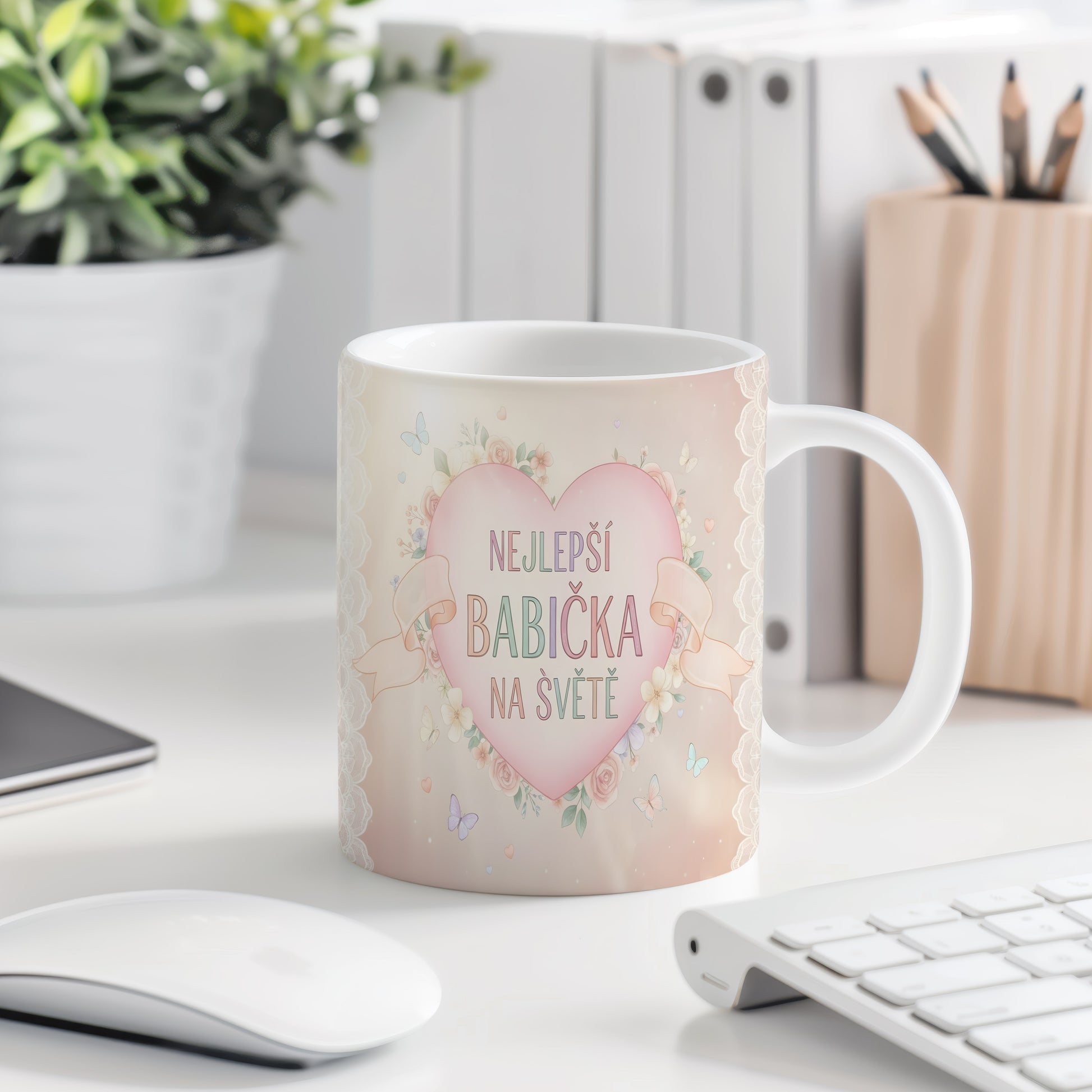 Hrnek s nápisem NEJLEPŠÍ BABIČKA NA SVĚTĚ, ozdobený květinami a motýly.