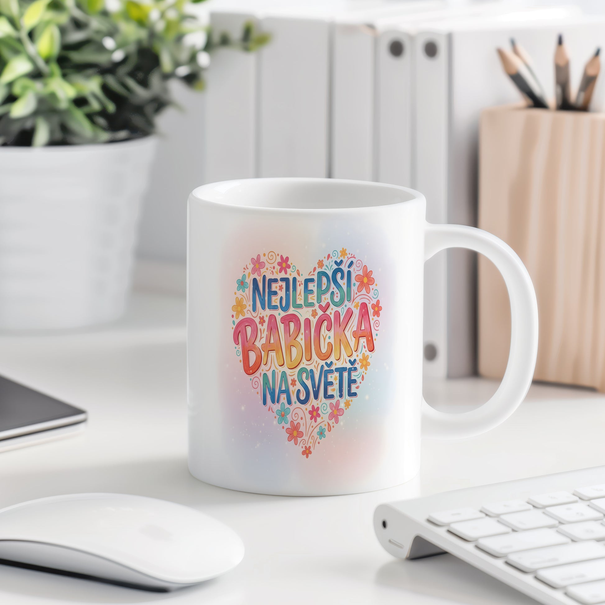 Hrnek s nápisem NEJLEPŠÍ BABIČKA NA SVĚTĚ a pastelovými květinami.
