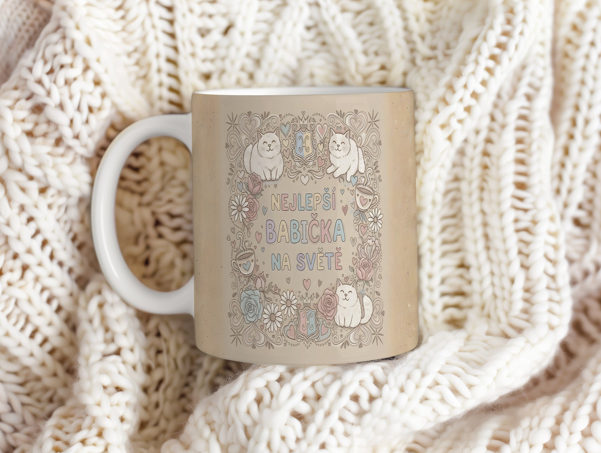 Hrnek s nápisem 'NEJLEPŠÍ BABIČKA NA SVĚTĚ', kočkami a květinami v pastelových barvách.