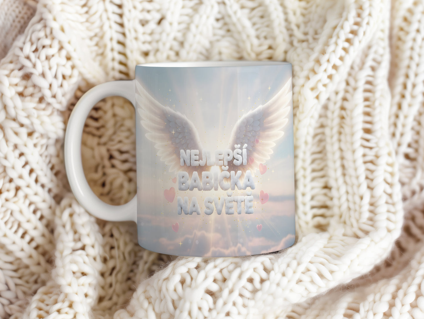 Hrnek s nápisem NEJLEPŠÍ BABIČKA NA SVĚTĚ, křídly a srdíčky na pastelovém pozadí.