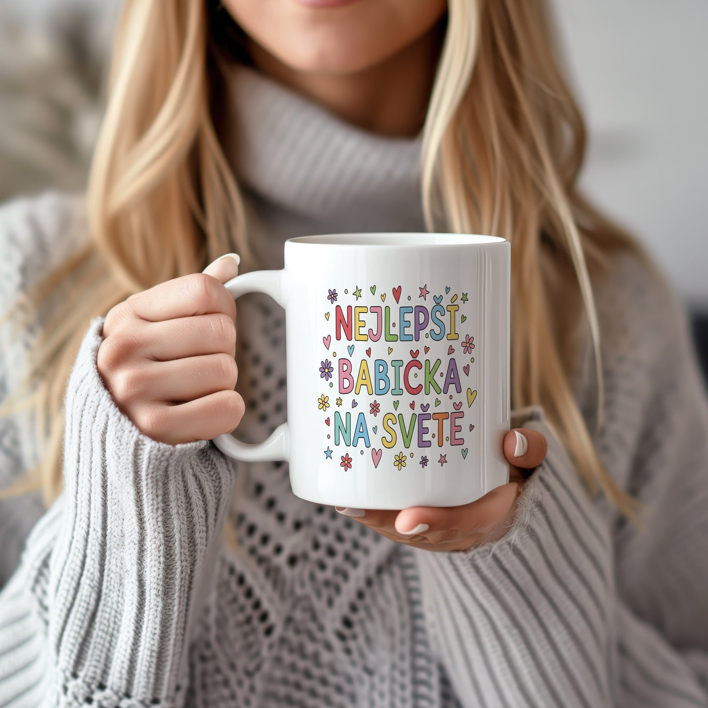 Bílý hrnek s barevnými nápisy, srdci a květinami.