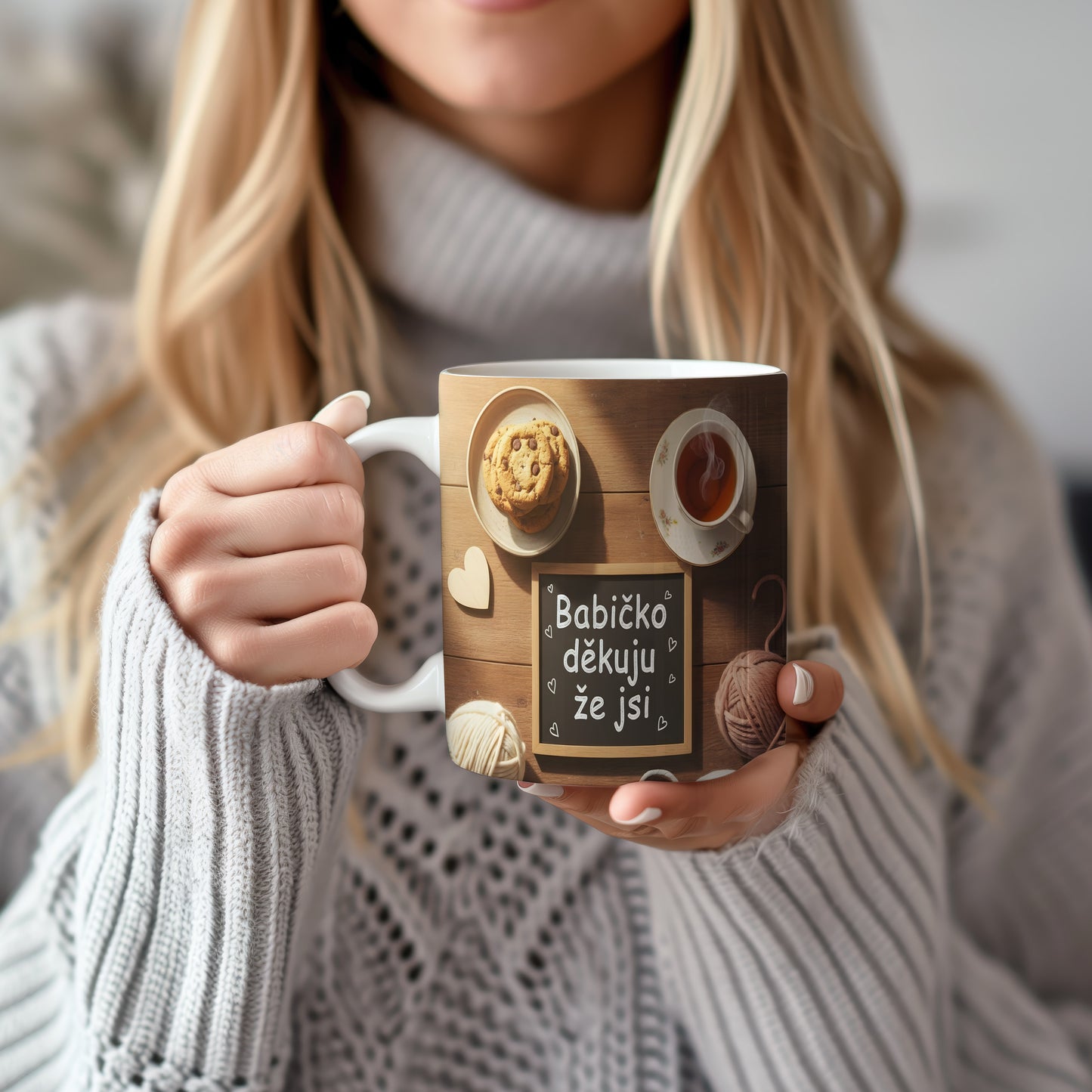 Hrnek s nápisem 'Babičko děkuju že jsi' na dřevěném pozadí s čajem a sušenkami.