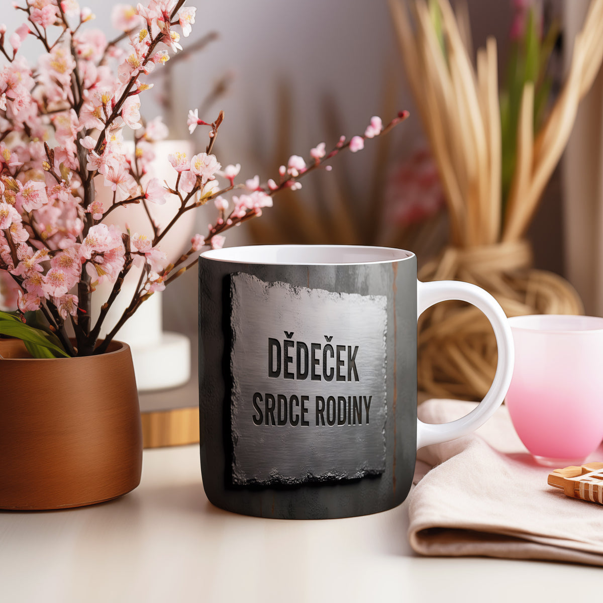 Rustikální hrnek s nápisem 'DĚDEČEK SRDCE RODINY' na kovovém pozadí.