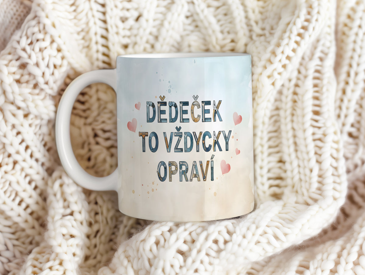 Hrnek s nápisem 'DĚDEČEK TO VŽDYCKY OPRAVÍ' a růžovými srdíčky na akvarelovém pozadí.