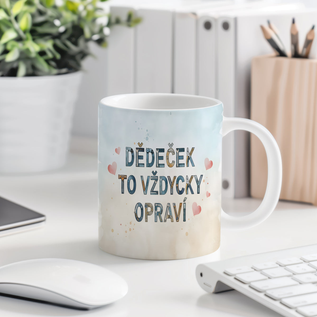Hrnek s nápisem 'DĚDEČEK TO VŽDYCKY OPRAVÍ' a růžovými srdíčky na akvarelovém pozadí.