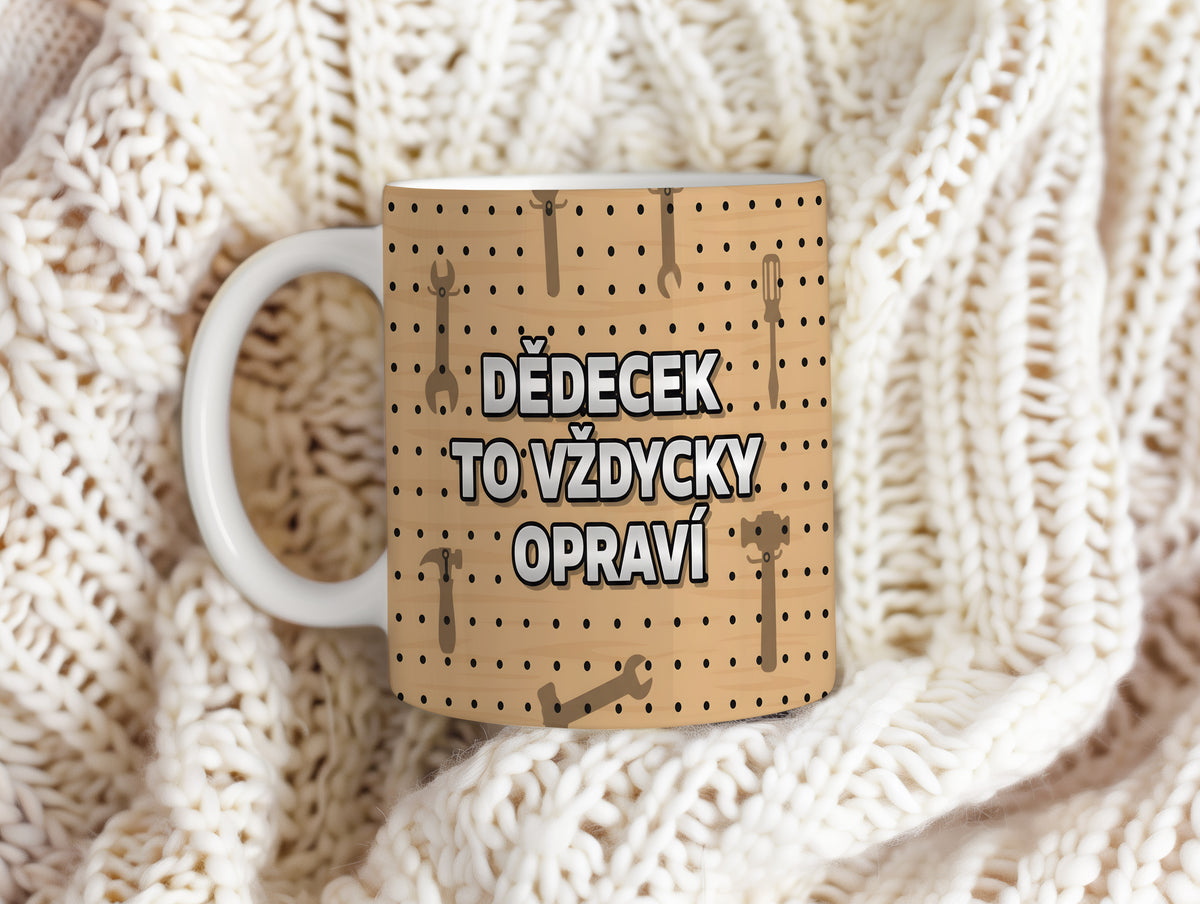 Hrnek s nápisem DĚDEČEK TO VŽDYCKY OPRAVÍ na dřevěném pozadí s nástroji.