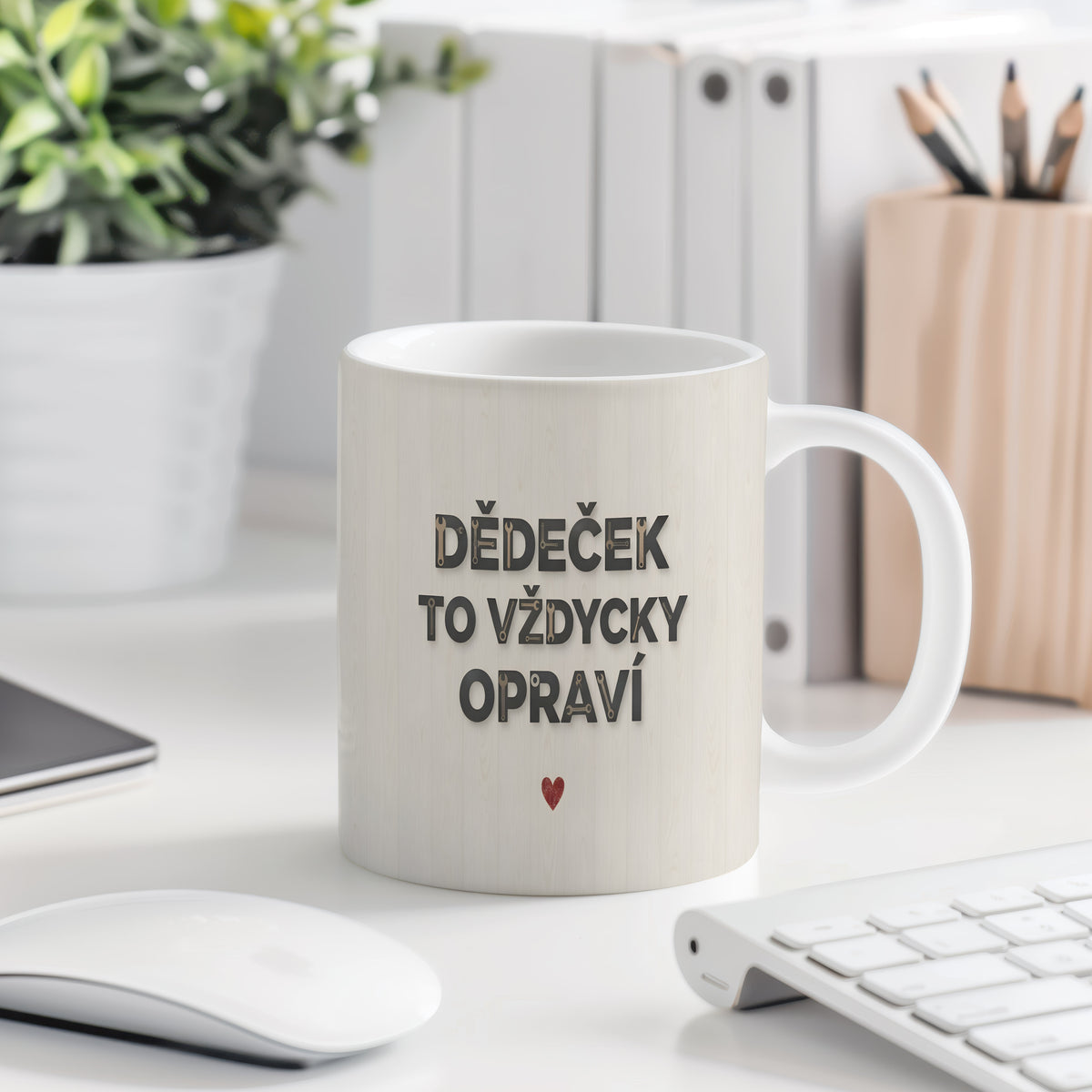 Bílý hrnek s nápisem 'DĚDEČEK TO VŽDYCKY OPRAVÍ' a červeným srdcem na dřevěném pozadí.