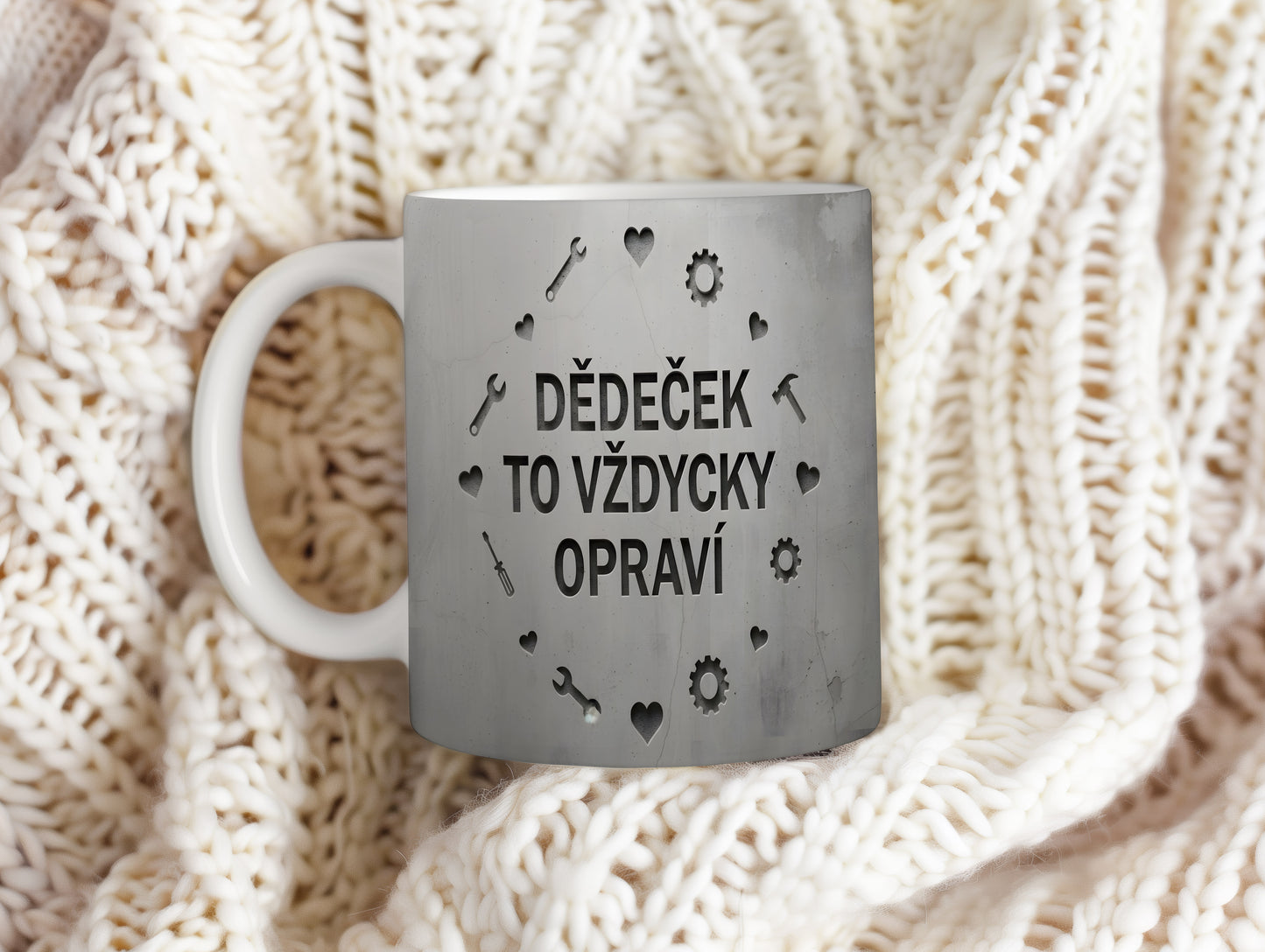 Hrnek s nápisem 'DĚDEČEK TO VŽDYCKY OPRAVÍ' a motivem nářadí na betonovém pozadí.