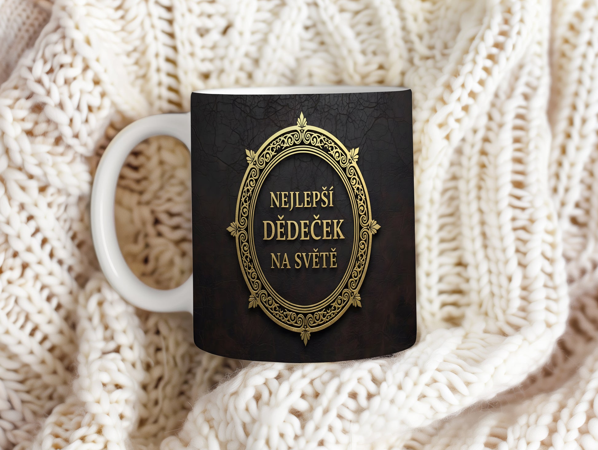 Hrnek s nápisem 'NEJLEPŠÍ DĚDEČEK NA SVĚTĚ' se zlatými ornamenty na černém pozadí.