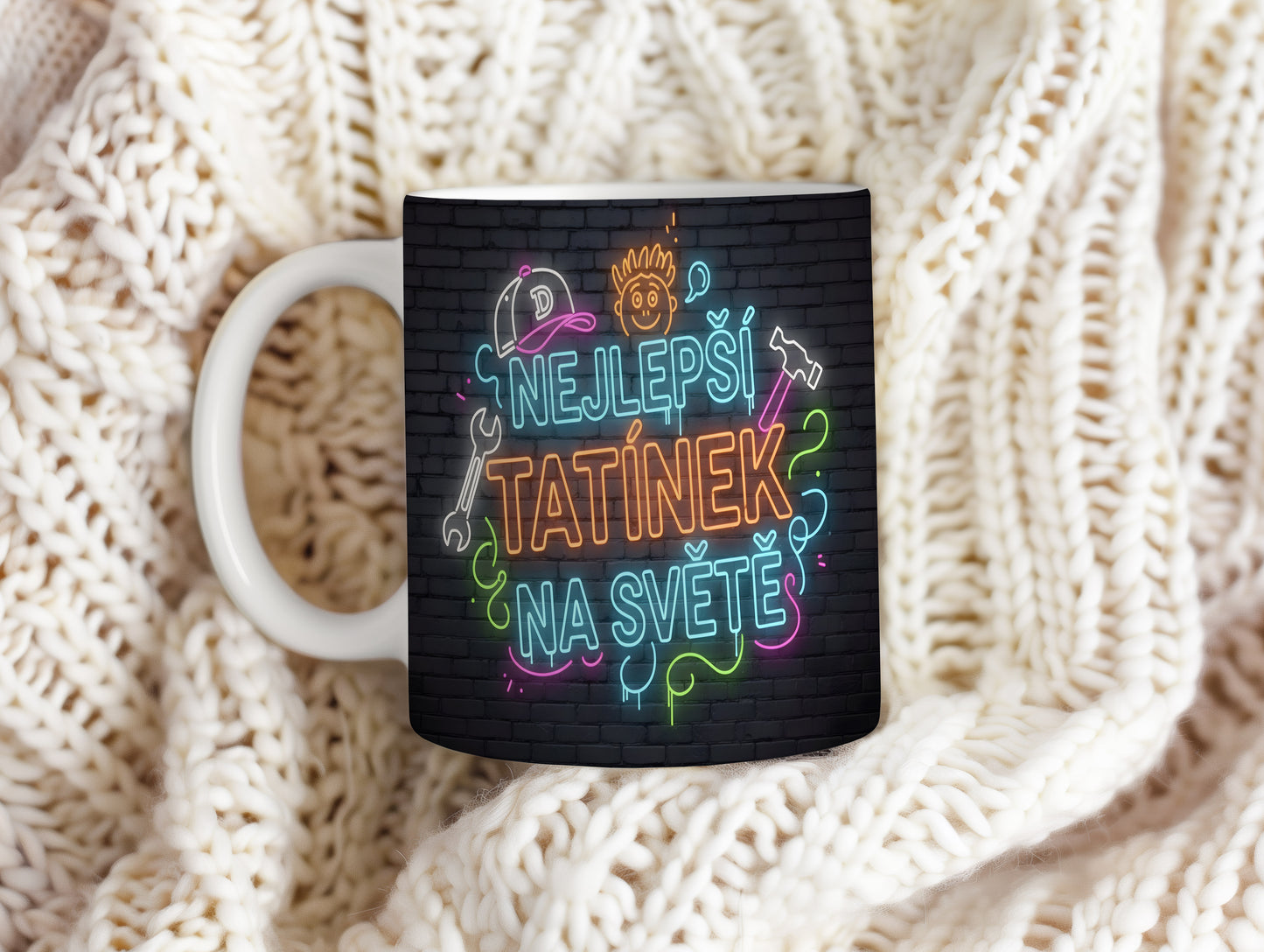 Hrnek s neonovým nápisem NEJLEPŠÍ TATÍNEK NA SVĚTĚ na cihlovém pozadí.