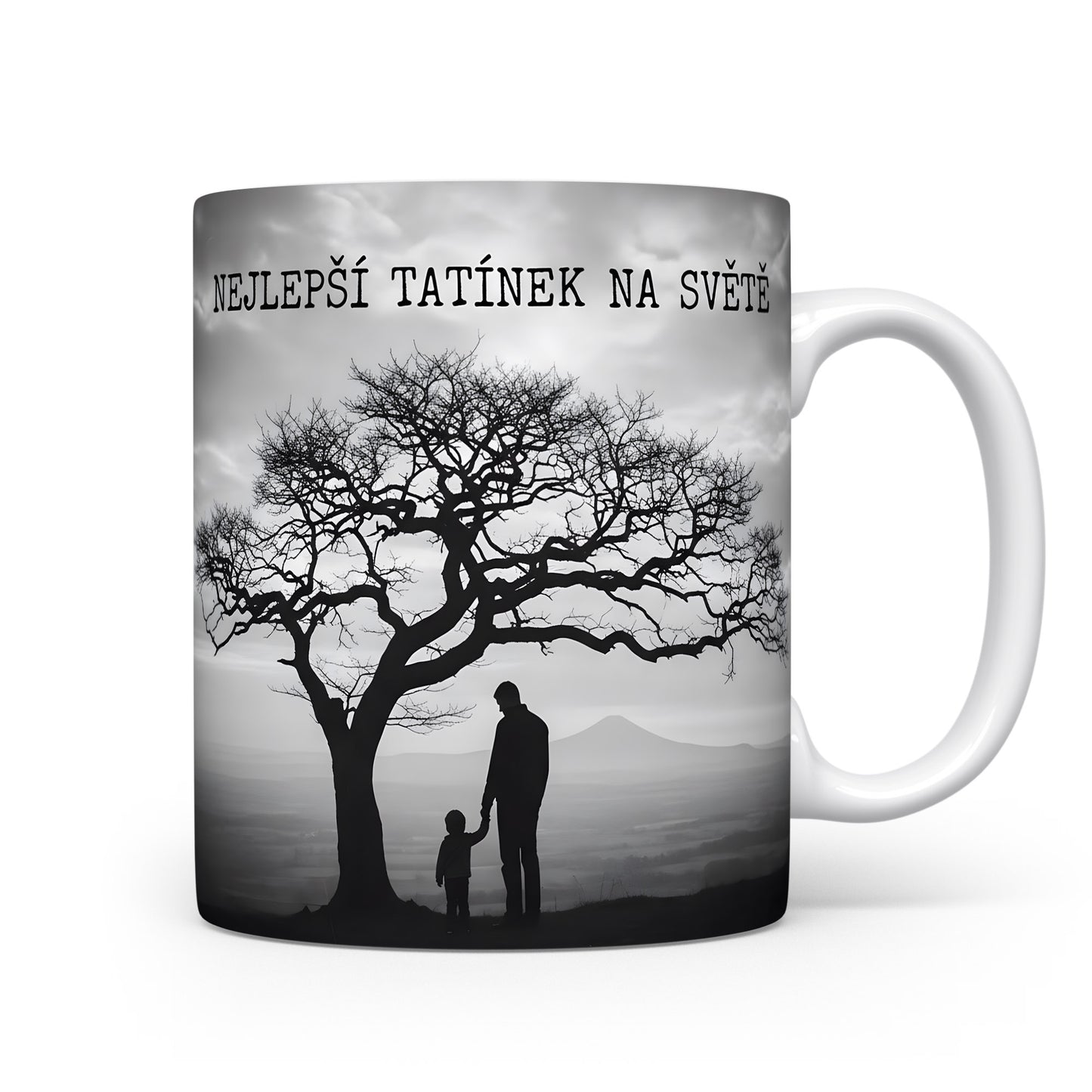 Hrnek s černobílou siluetou otce a dítěte pod stromem.