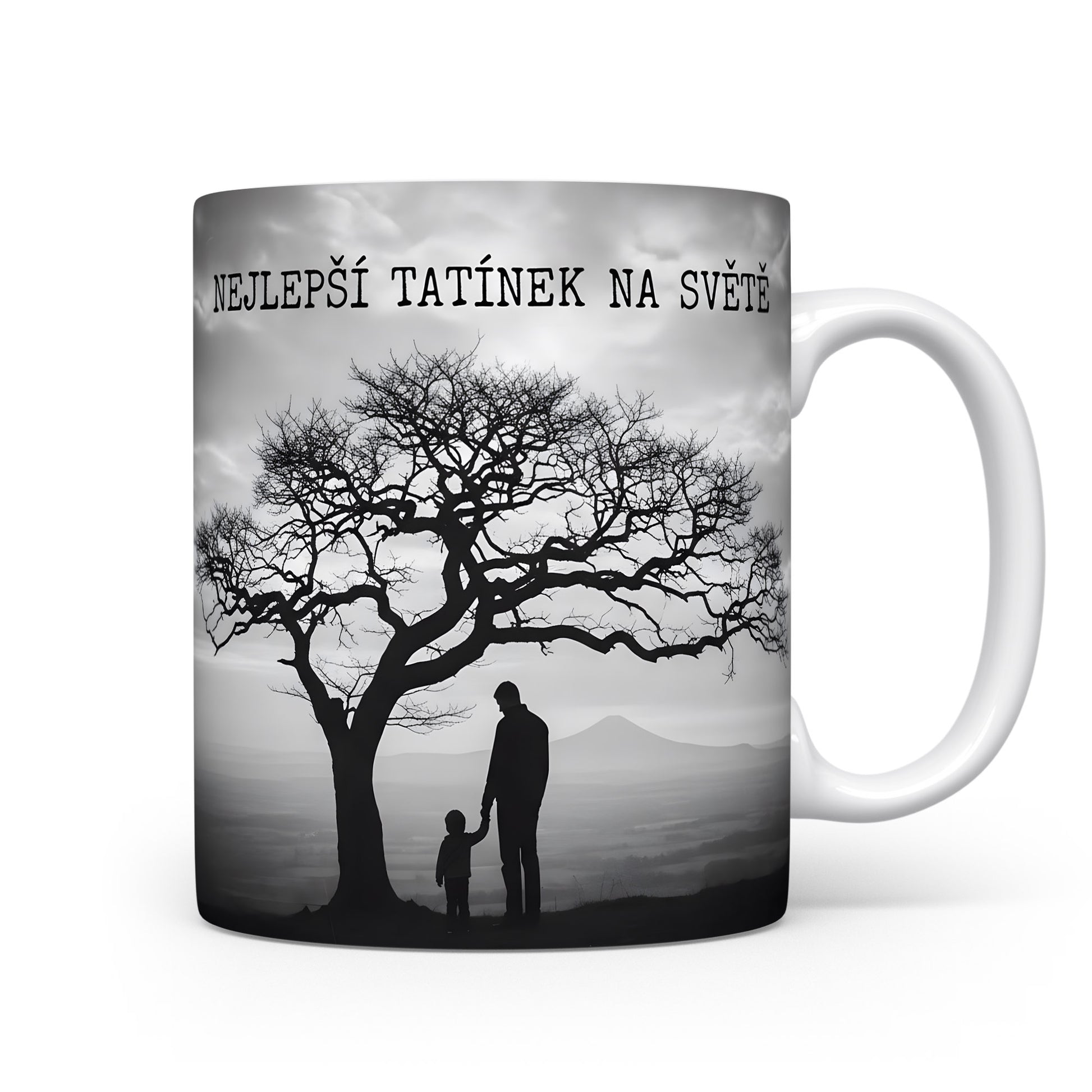 Hrnek s černobílou siluetou otce a dítěte pod stromem.