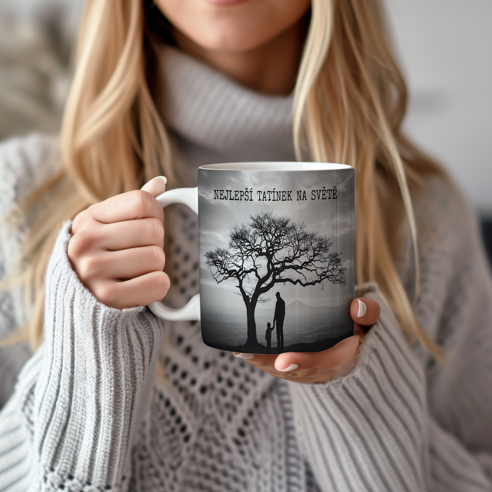 Hrnek s černobílou siluetou otce a dítěte pod stromem.