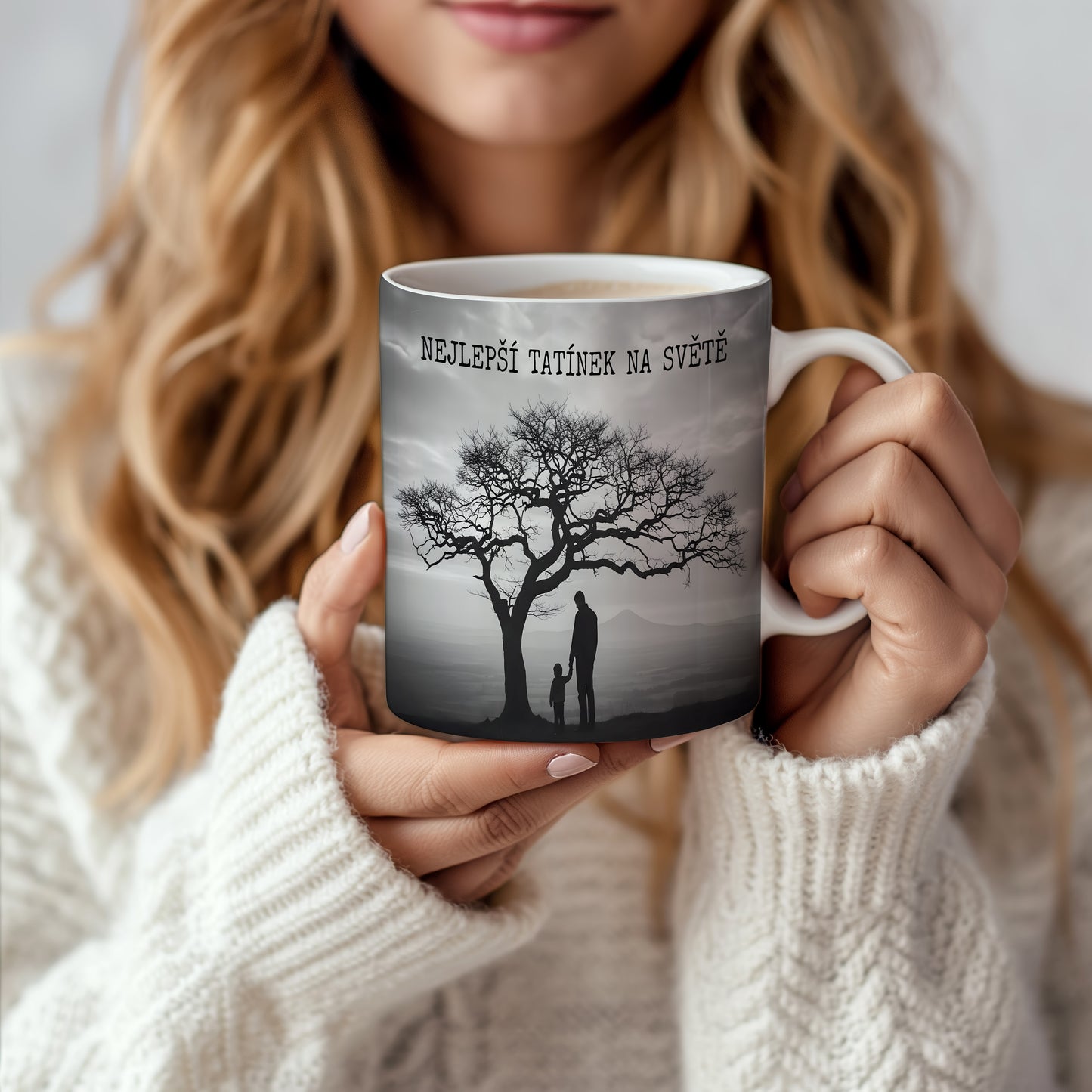 Hrnek s černobílou siluetou otce a dítěte pod stromem.