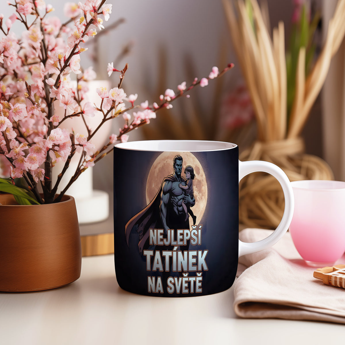 Hrnek s motivem superhrdiny držícího dítě před měsícem.