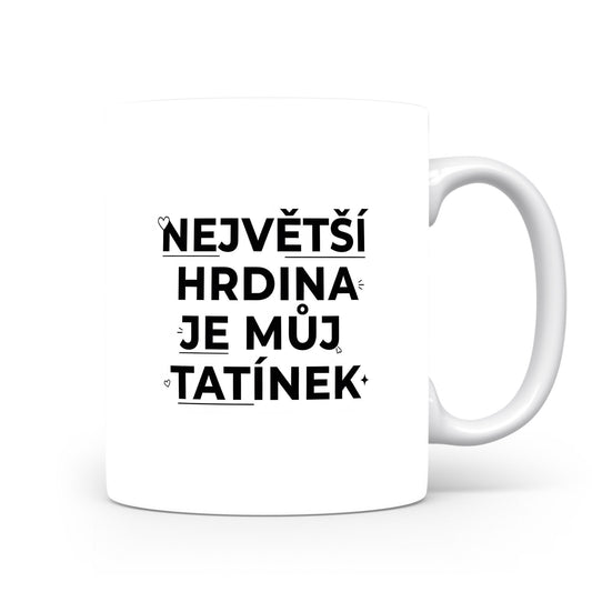 Bílý hrnek s černým nápisem 'NEJVĚTŠÍ HRDINA JE MŮJ TATÍNEK' a malými srdíčky.