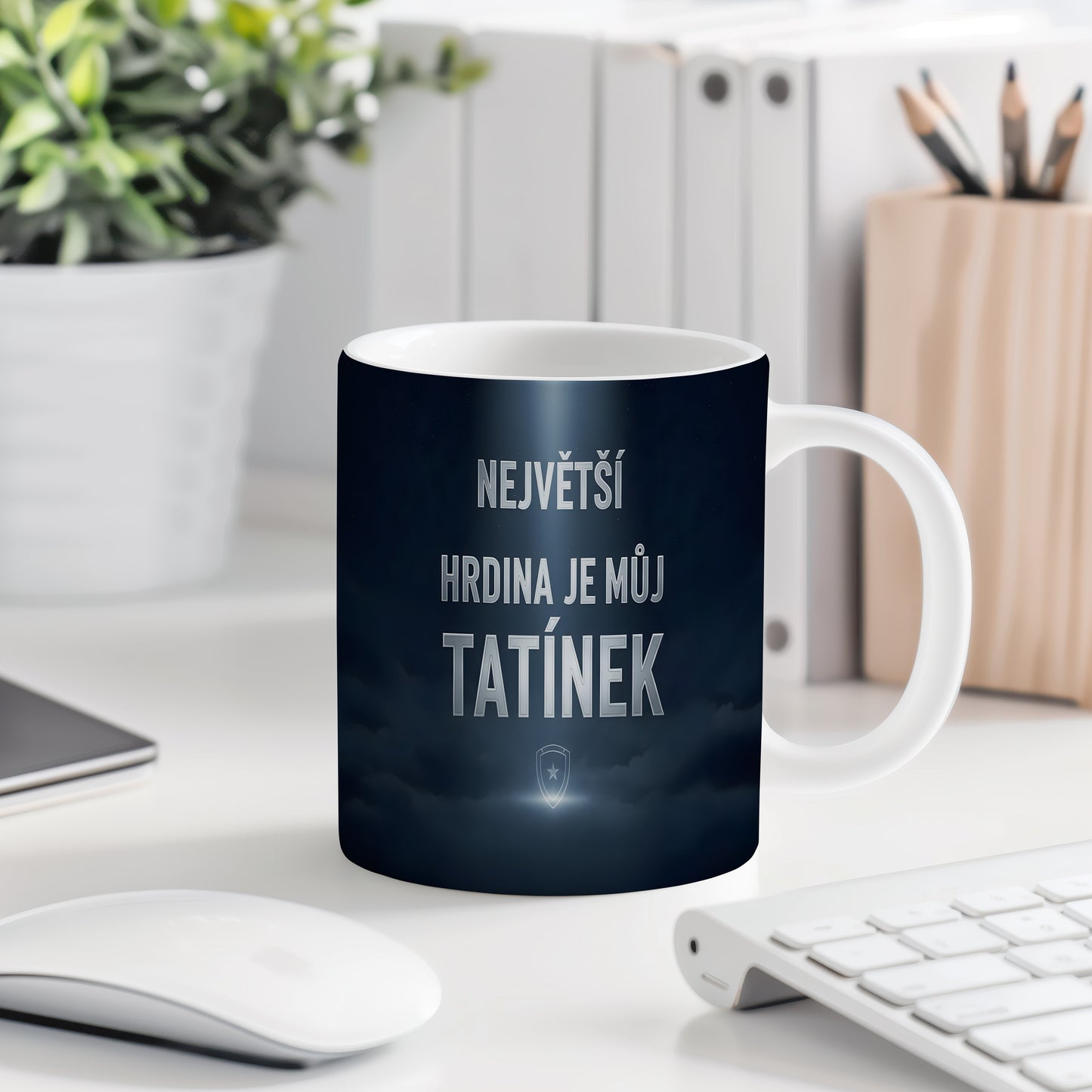 Tmavě modrý hrnek s nápisem NEJVĚTŠÍ HRDINA JE MŮJ TATÍNEK a motivem štítu.