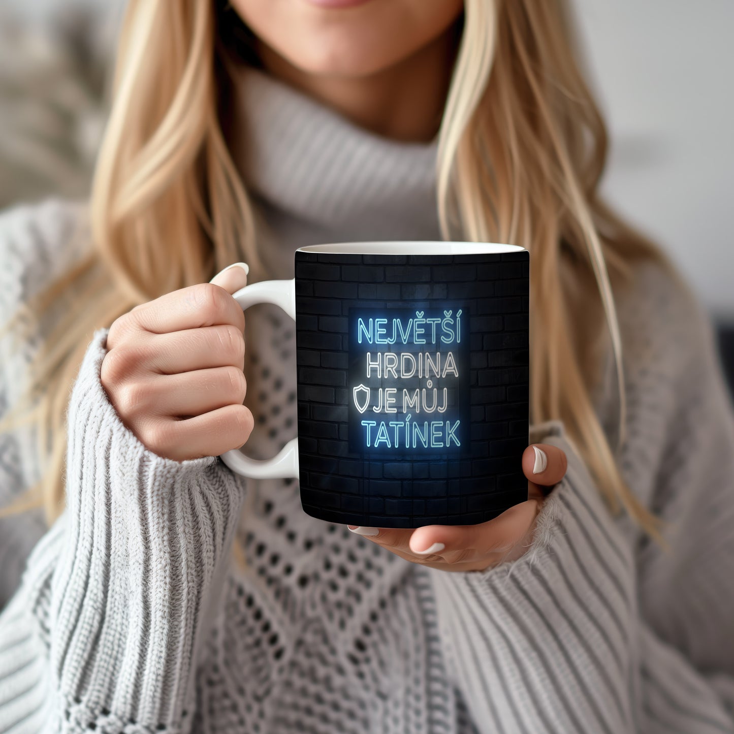 Hrnek s neonovým nápisem na cihlovém pozadí.