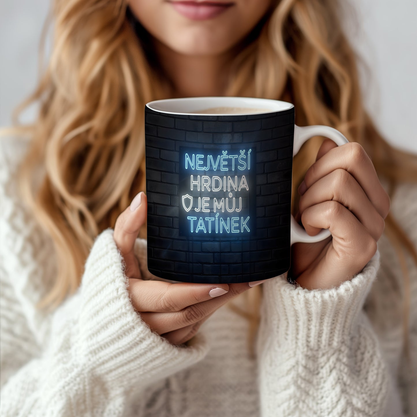 Hrnek s neonovým nápisem na cihlovém pozadí.