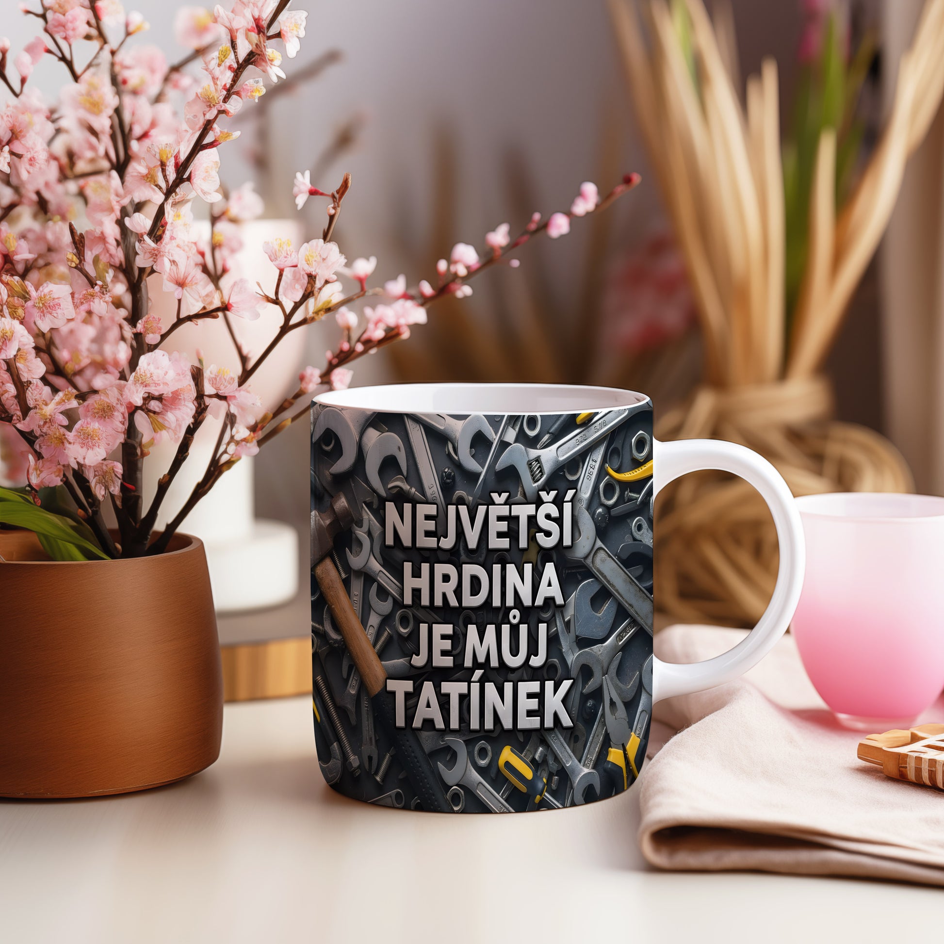 Hrnek s motivem nářadí a textem 'NEJVĚTŠÍ HRDINA JE MŮJ TATÍNEK'.