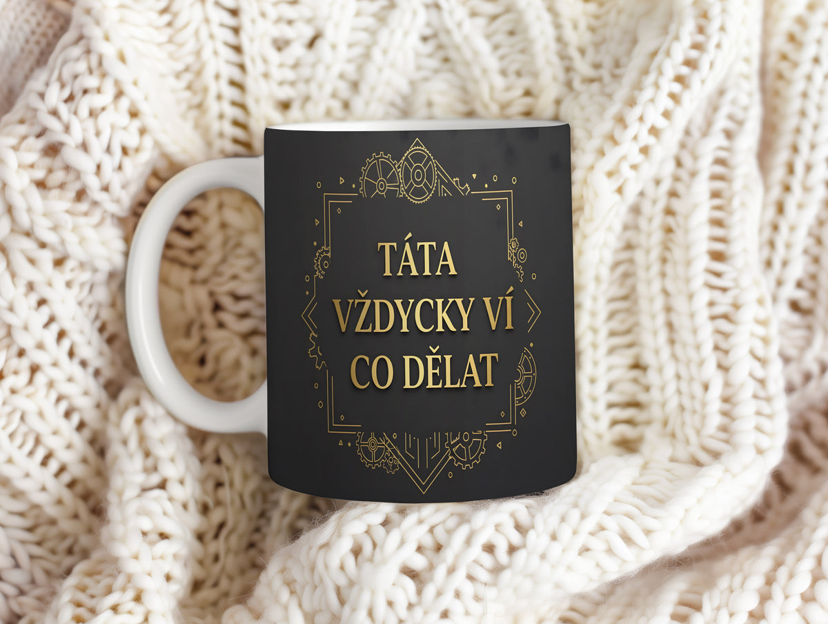 Černý hrnek se zlatým textem a technickým vzorem.