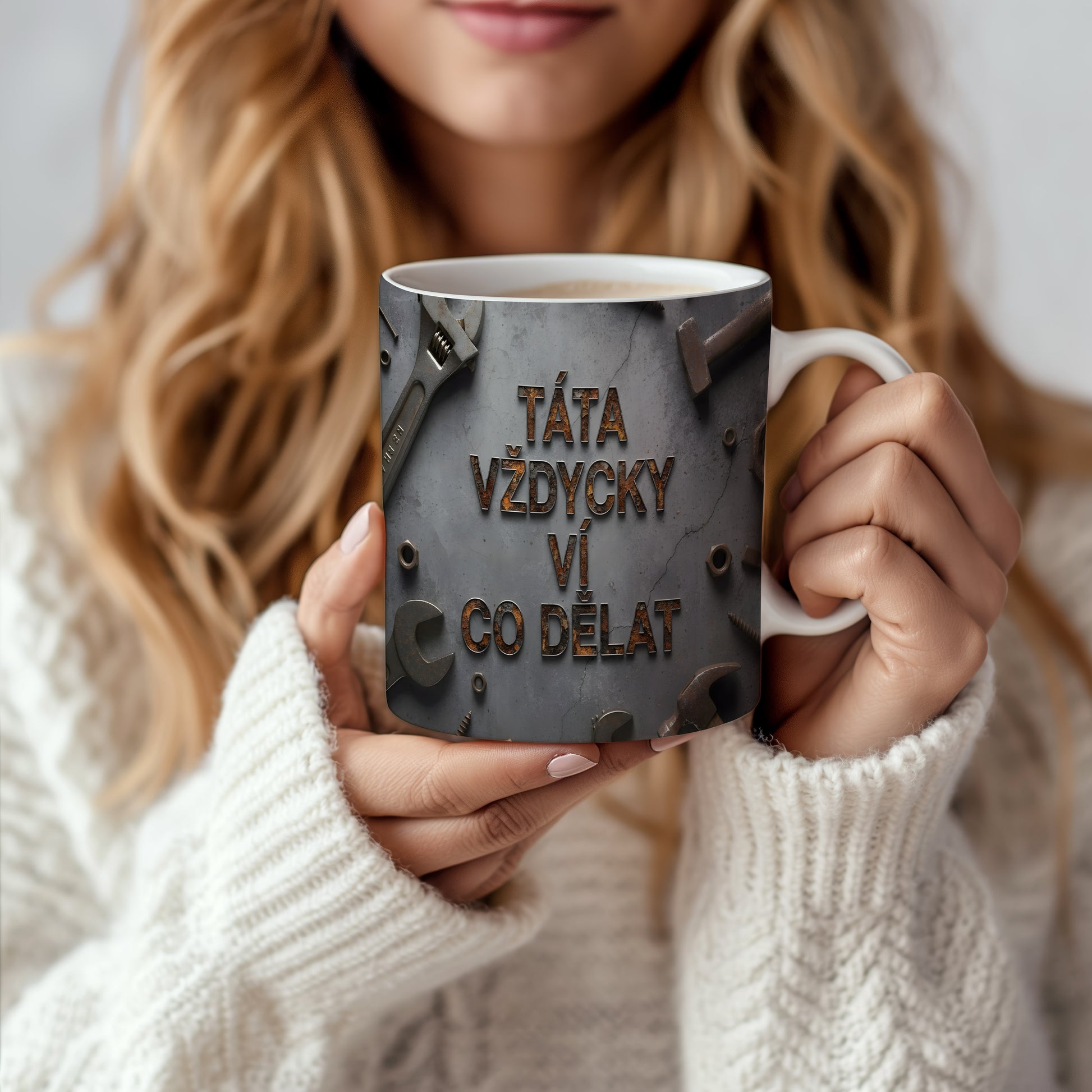 Hrnek s rezavým textem a motivem nářadí na betonovém pozadí.