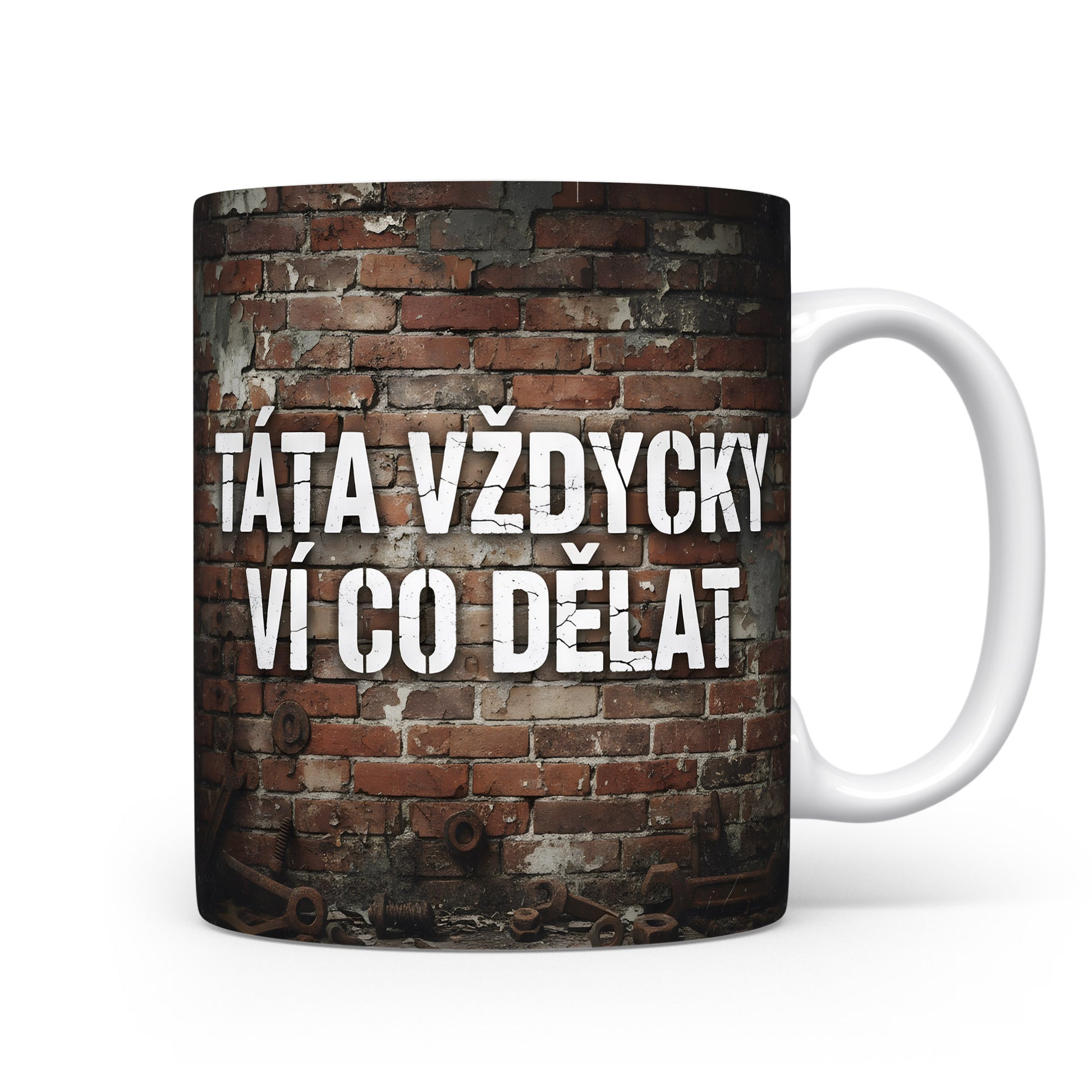 Hrnek s nápisem 'TÁTA VŽDYCKY VÍ CO DĚLAT' na cihlovém pozadí.