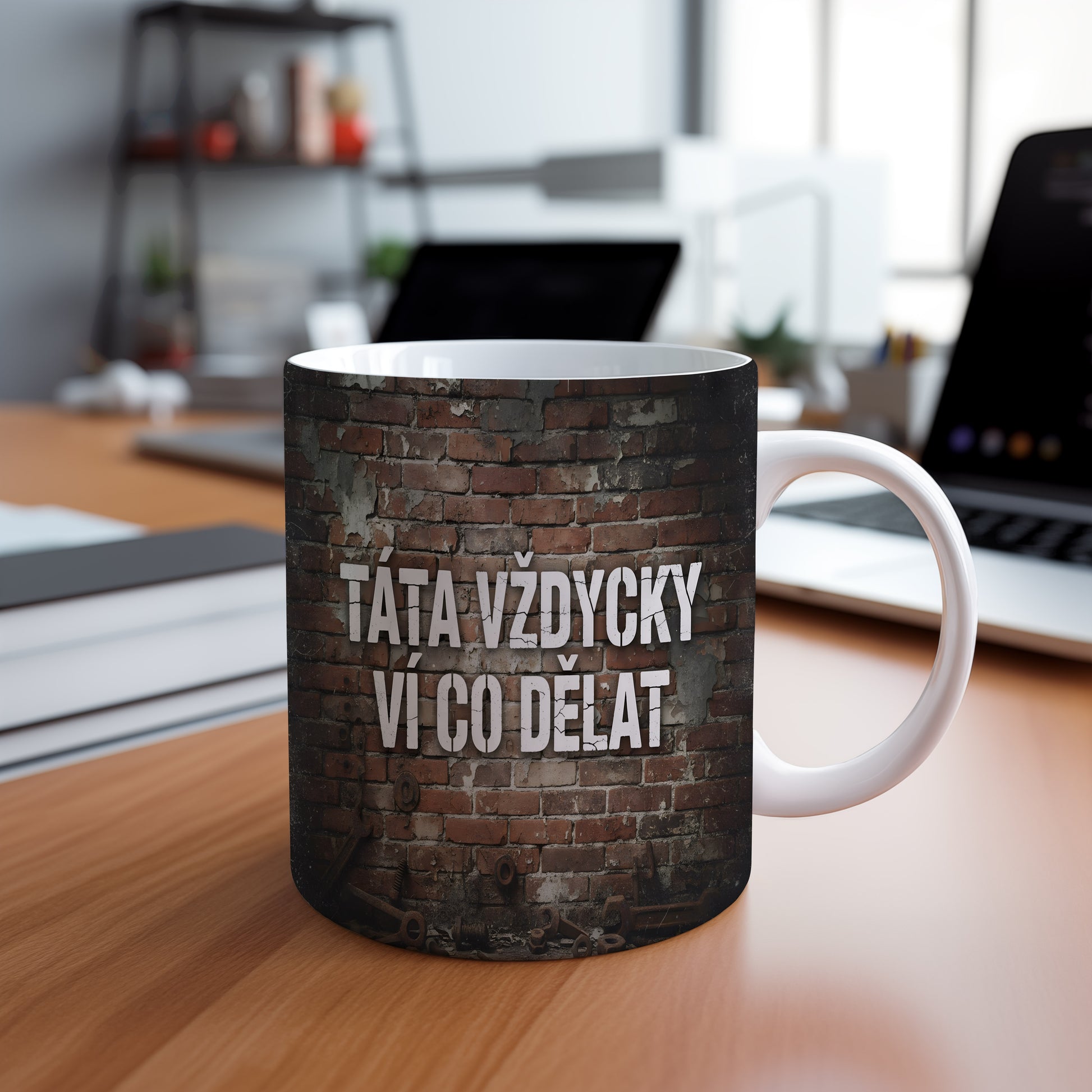 Hrnek s nápisem 'TÁTA VŽDYCKY VÍ CO DĚLAT' na cihlovém pozadí.
