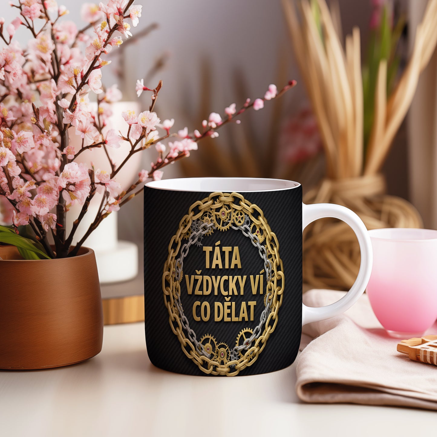 Hrnek s nápisem TÁTA VŽDYCKY VÍ CO DĚLAT s motivem řetězů a ozubených kol.