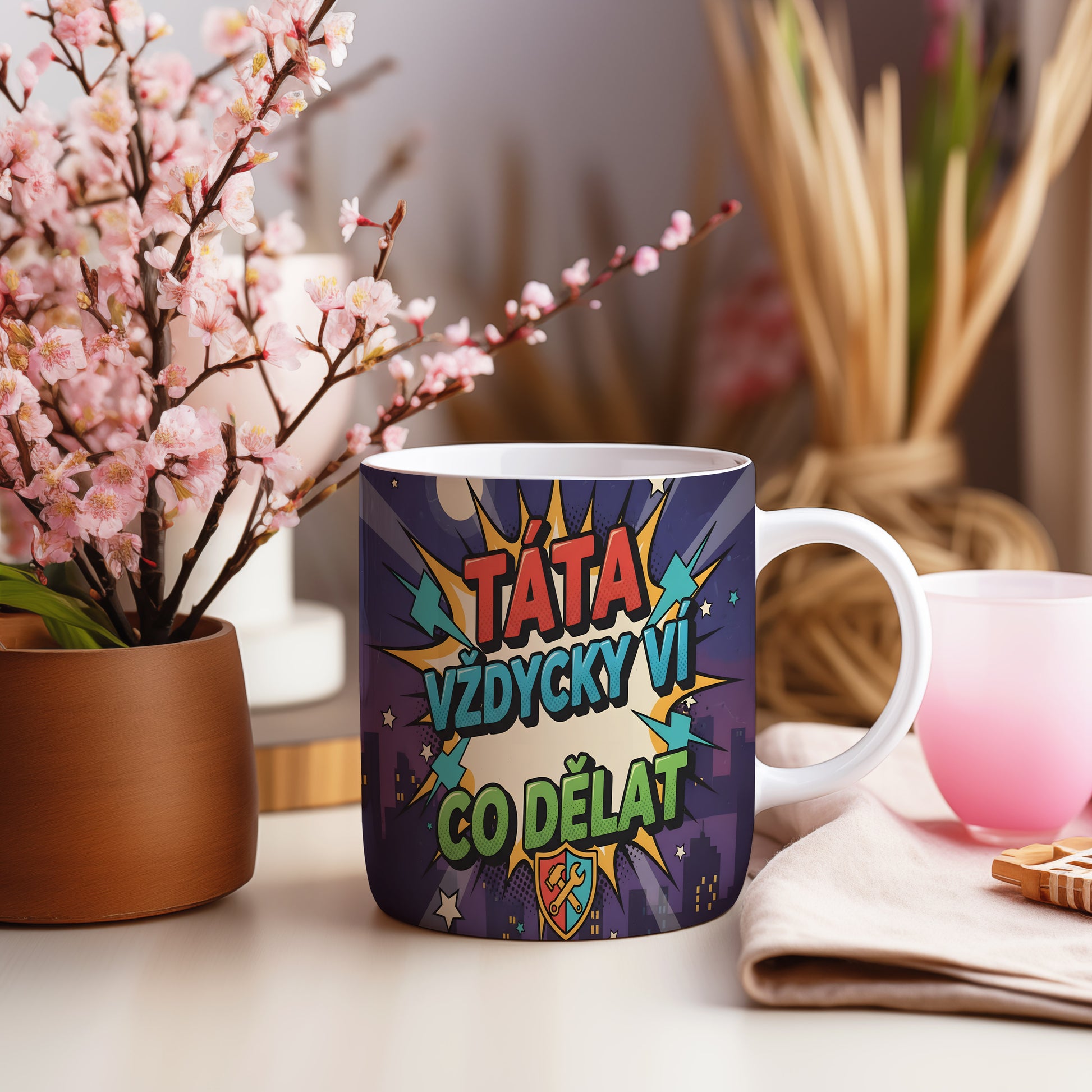 Komiksový hrnek s nápisem 'TÁTA VŽDYCKY VÍ CO DĚLAT' v pestrých barvách.