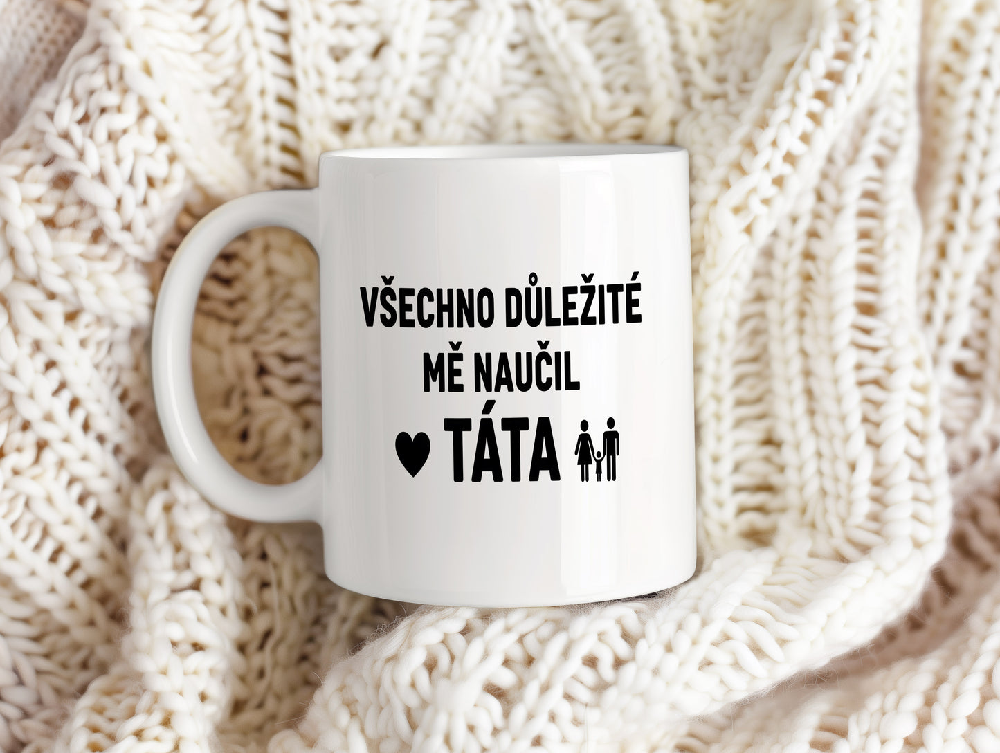 Bílý hrnek s černým textem a symbolem rodiny.