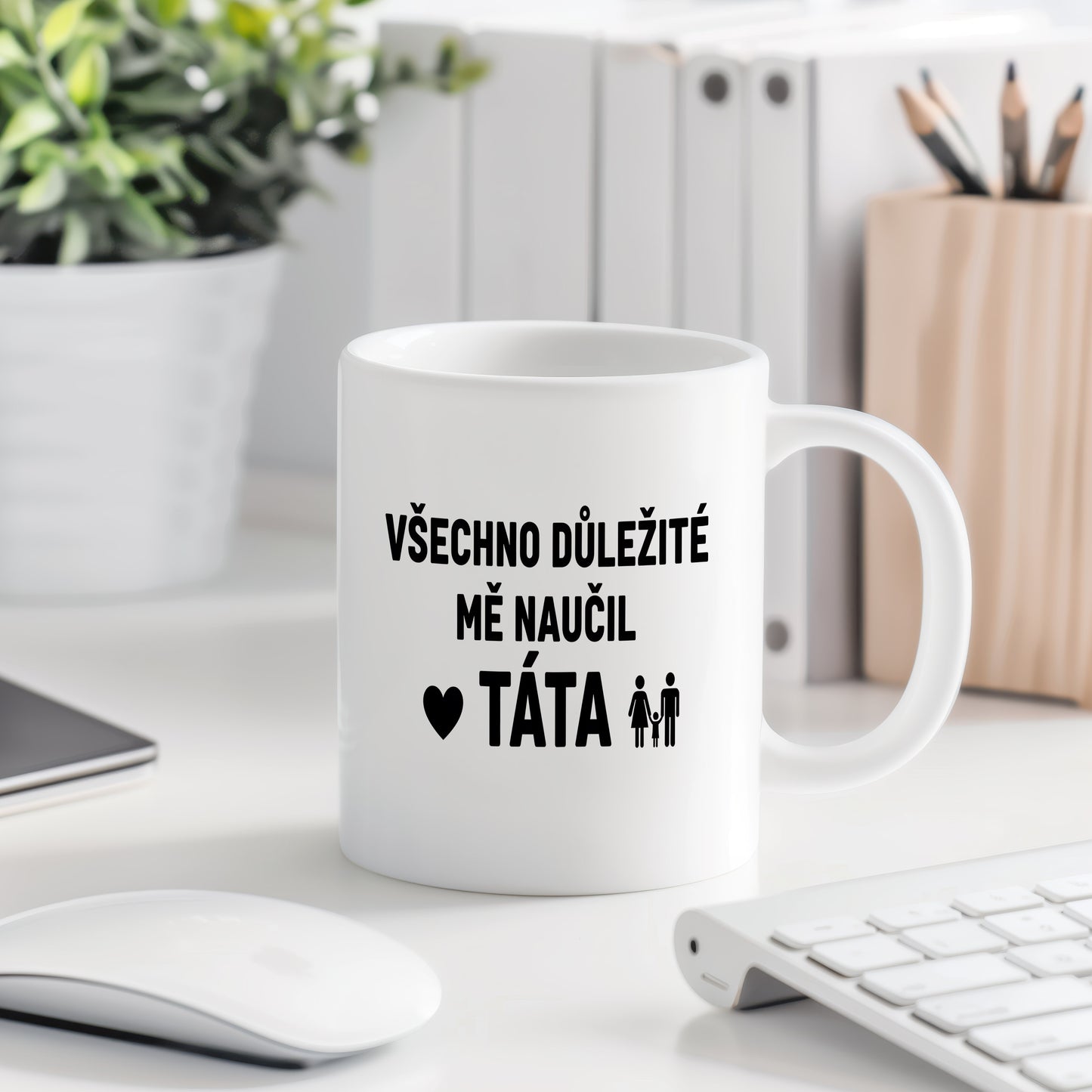 Bílý hrnek s černým textem a symbolem rodiny.