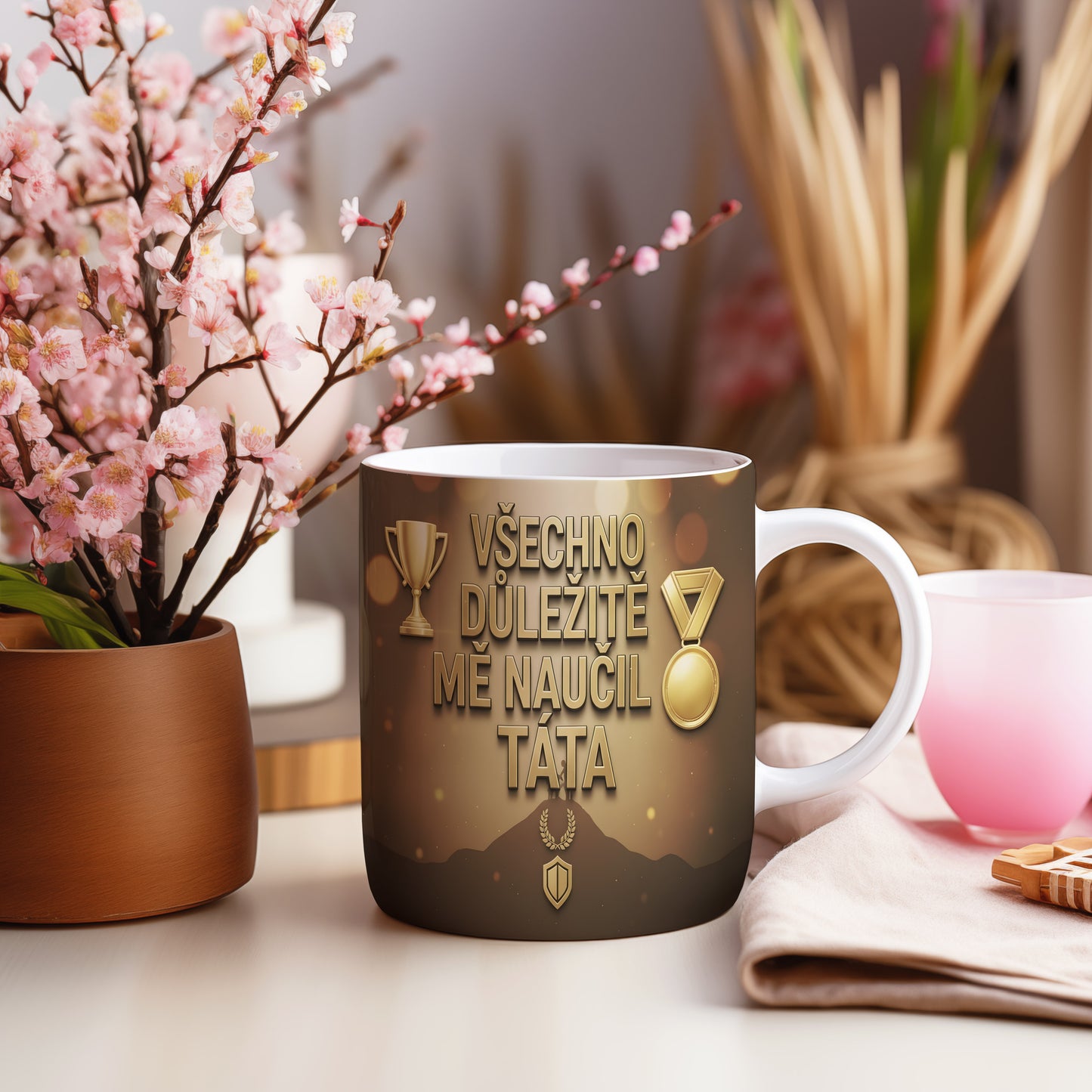Hrnek se zlatými trofejemi a nápisem VŠECHNO DŮLEŽITÉ MĚ NAUČIL TÁTA.