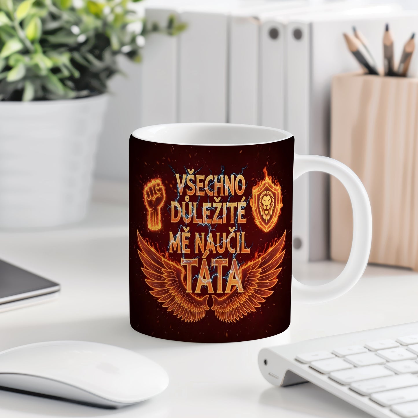 Černý hrnek s oranžovými motivy křídel, pěsti a lva.