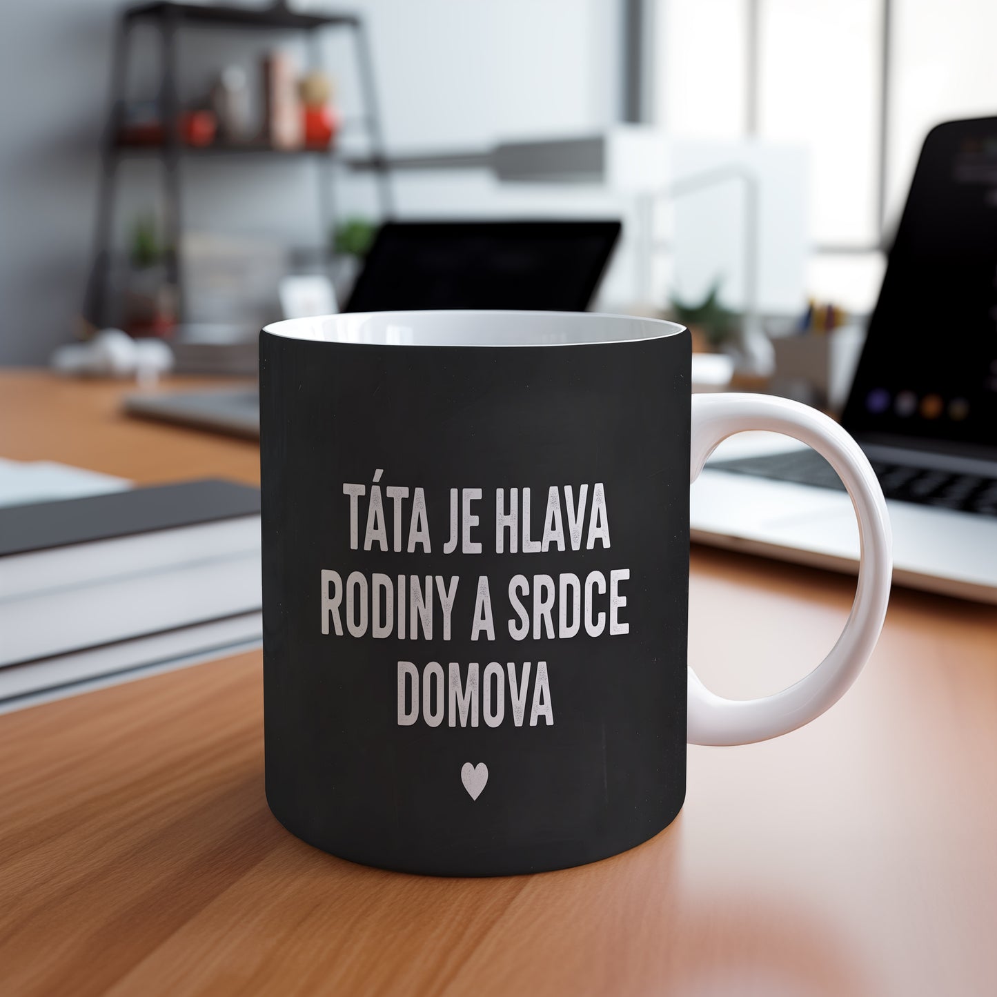 Černý hrnek s bílým nápisem TÁTA JE HLAVA RODINY A SRDCE DOMOVA a malým srdcem.