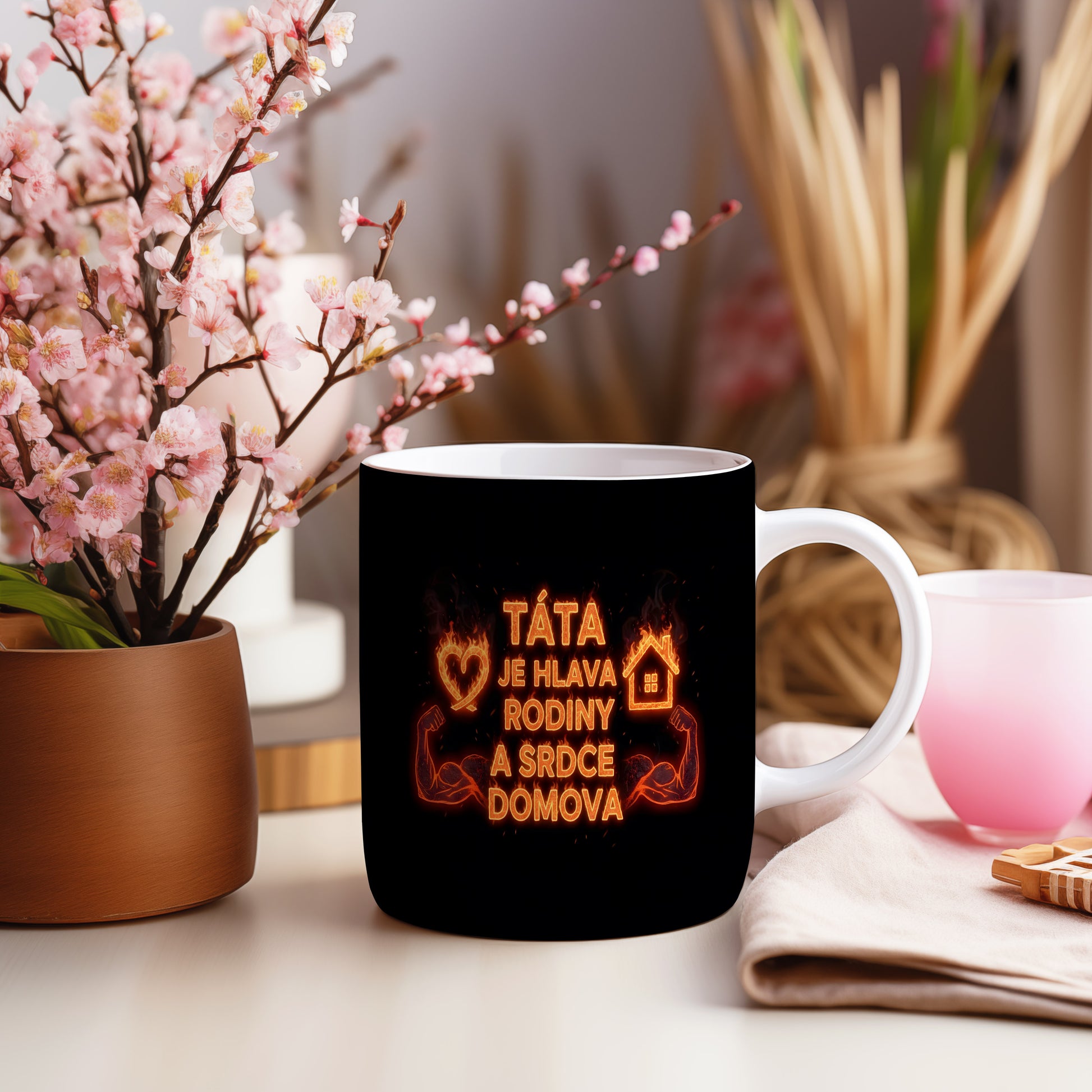 Černý hrnek s oranžovým ohnivým nápisem a motivy srdce a domova.