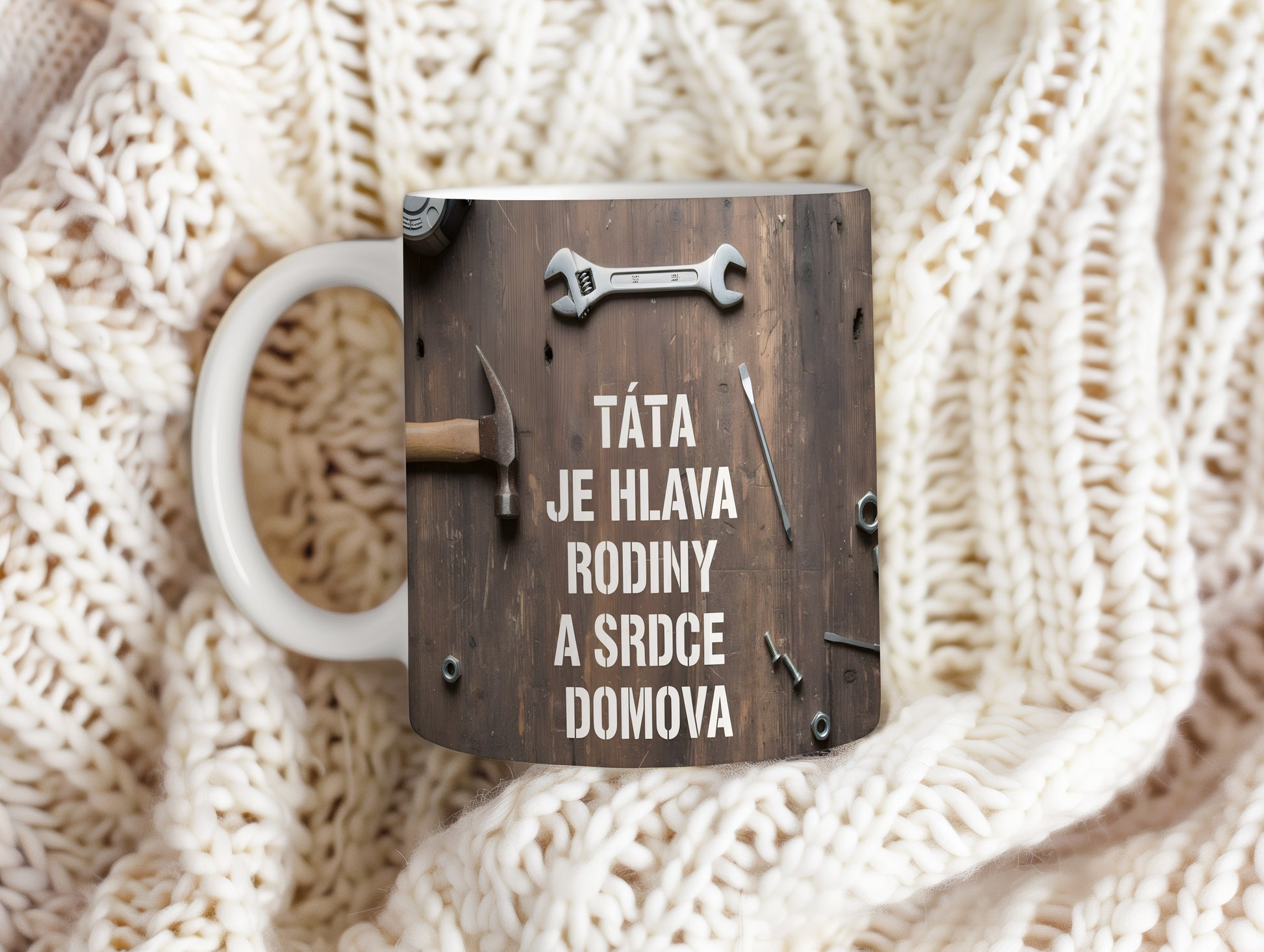 Rustikální hrnek s textem a nářadím na dřevěném pozadí.