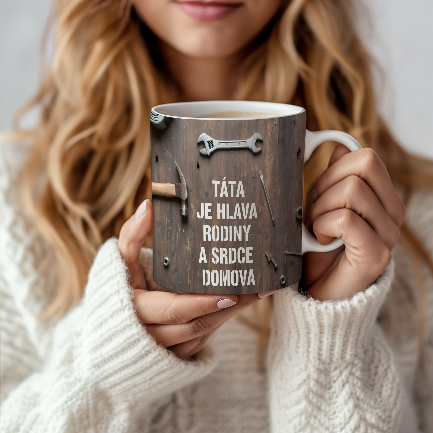 Rustikální hrnek s textem a nářadím na dřevěném pozadí.