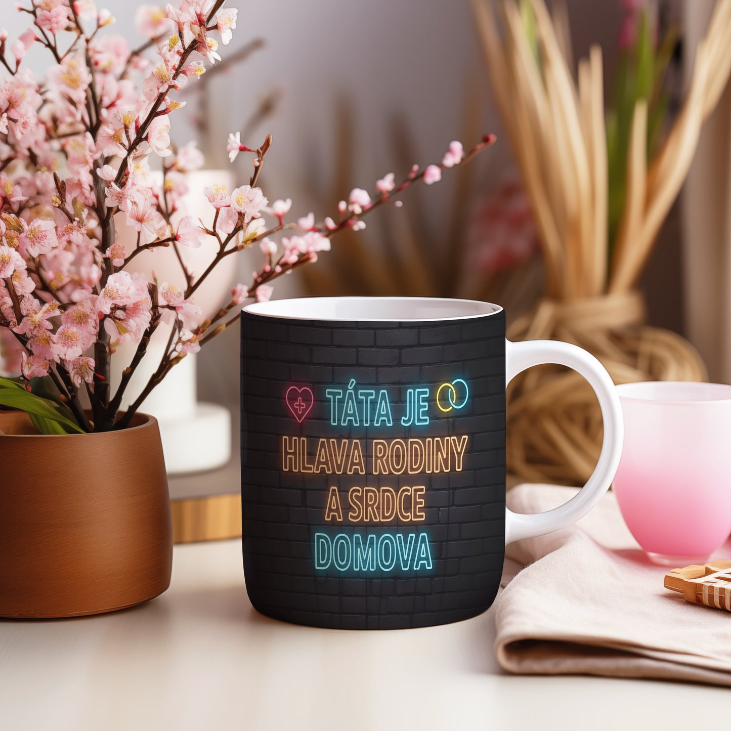 Hrnek s nápisem TÁTA JE HLAVA RODINY A SRDCE DOMOVA na cihlovém pozadí.