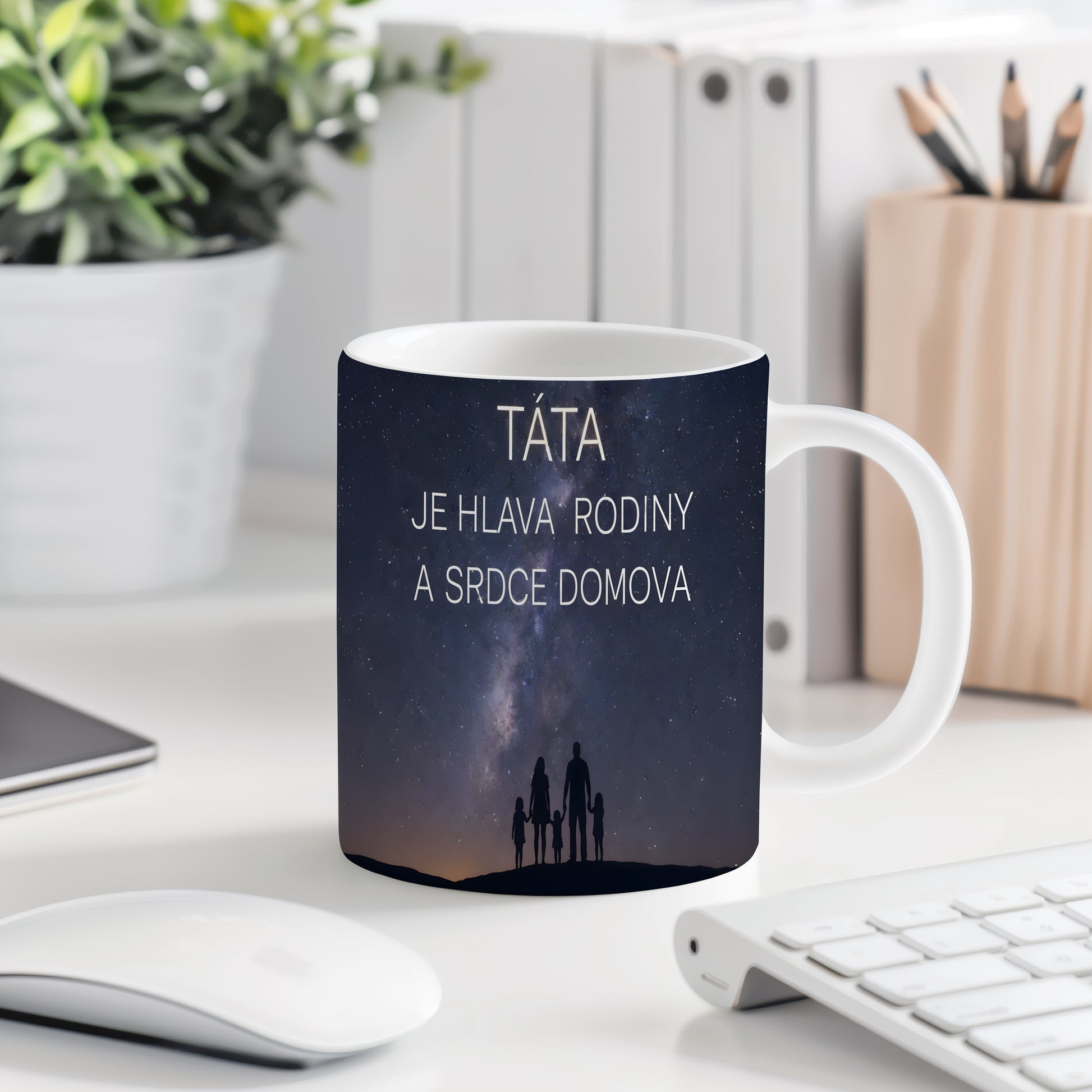 Hrnek s nápisem TÁTA JE HLAVA RODINY A SRDCE DOMOVA a siluetou rodiny pod hvězdnou oblohou.