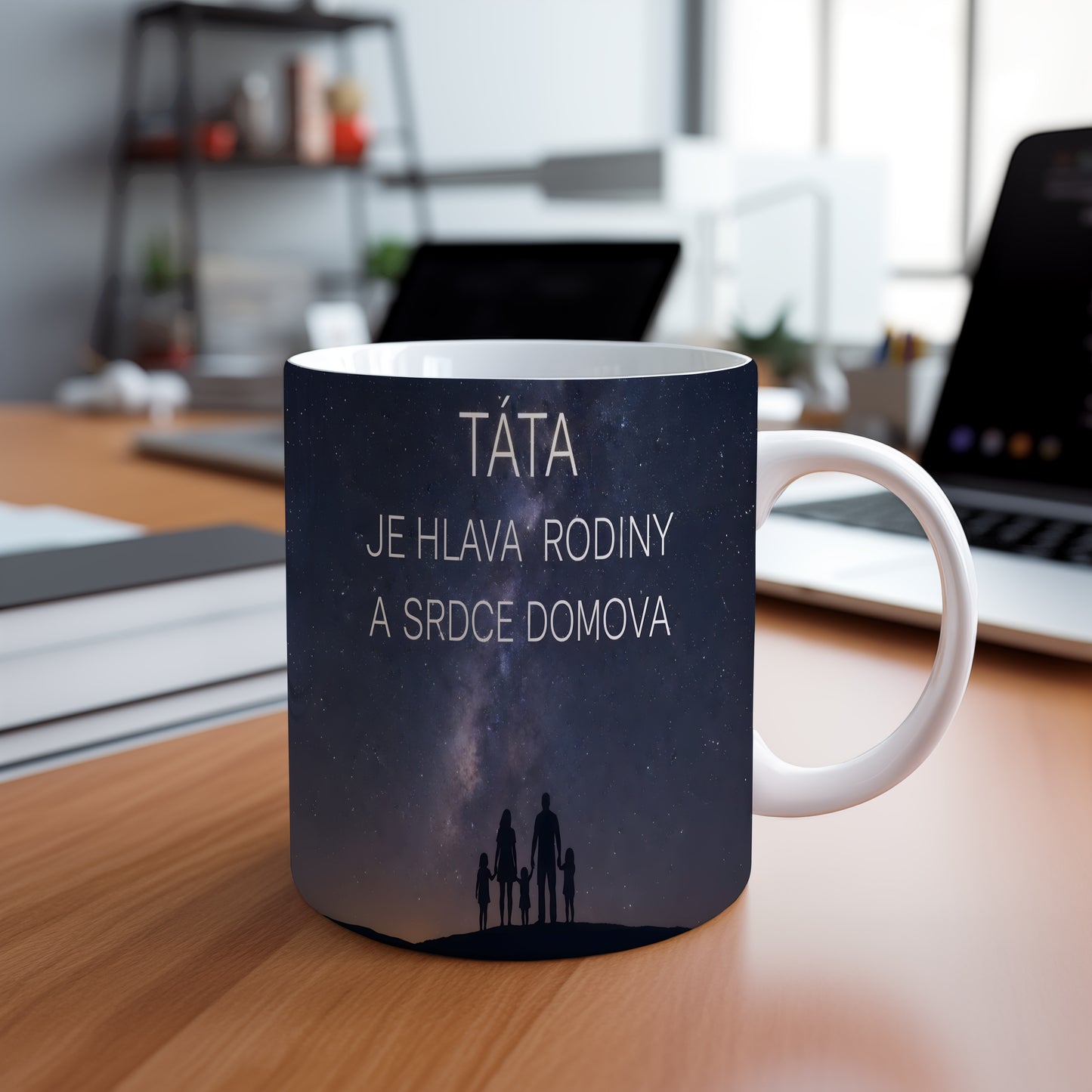 Hrnek s nápisem TÁTA JE HLAVA RODINY A SRDCE DOMOVA a siluetou rodiny pod hvězdnou oblohou.