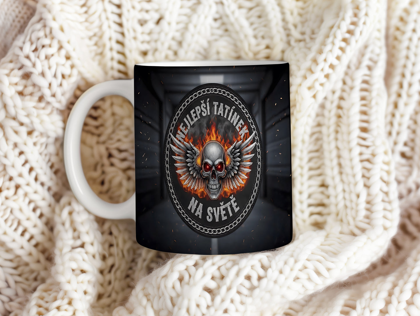 Hrnek s motivem lebky, křídel a plamenů.