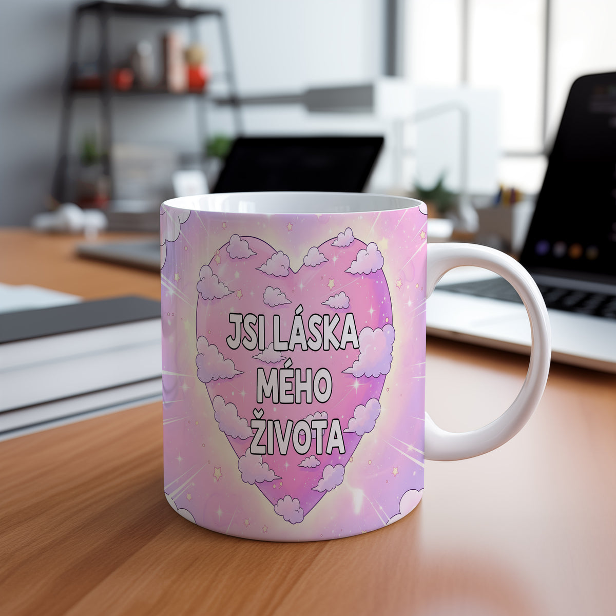 Růžový hrnek s nápisem JSI LÁSKA MÉHO ŽIVOTA obklopený mraky a hvězdami.