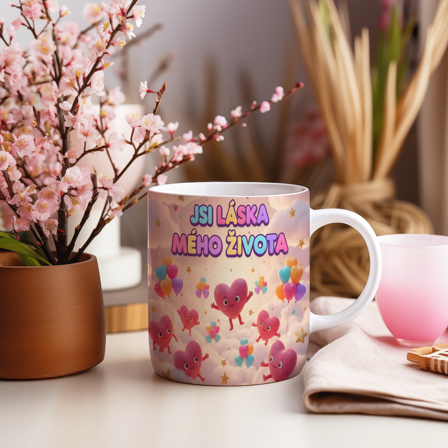 Hrnek s nápisem JSI LÁSKA MÉHO ŽIVOTA a motivem srdcí a balónků.