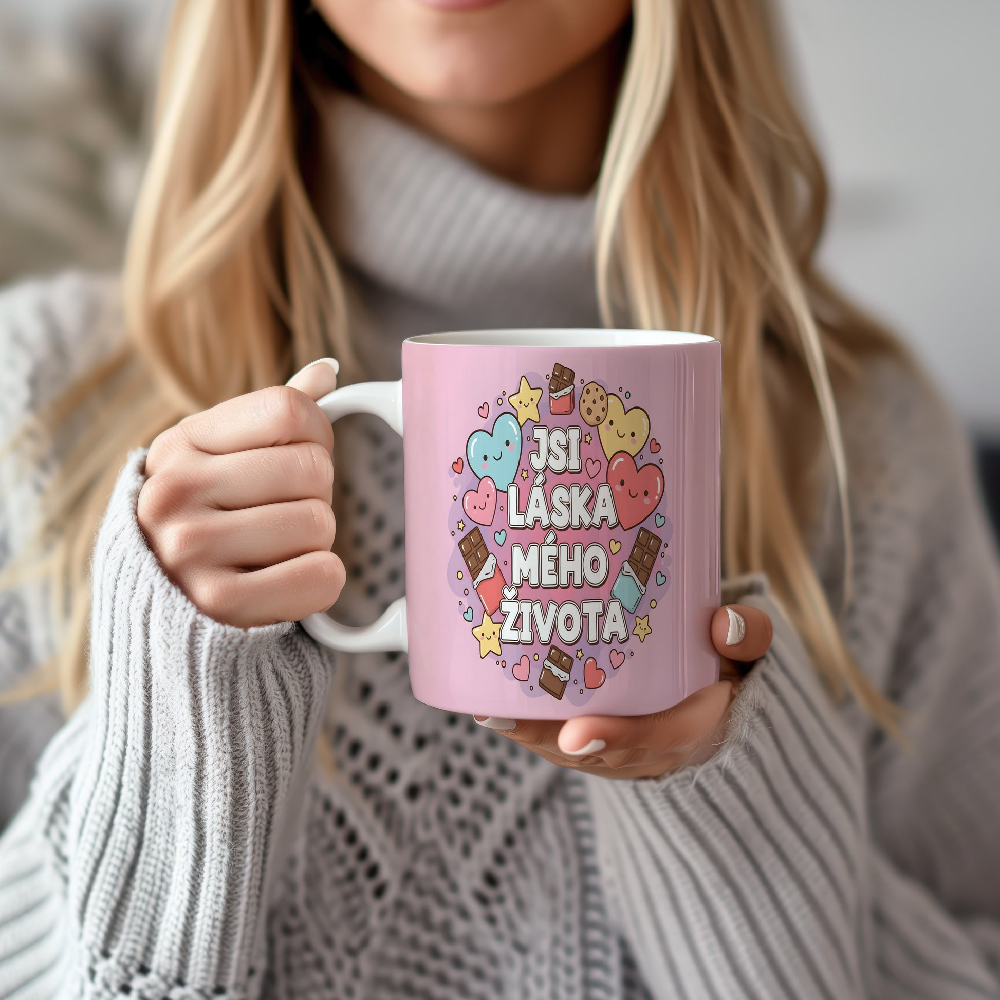 Růžový hrnek s nápisem 'JSI LÁSKA MÉHO ŽIVOTA' a motivy srdcí a sladkostí.